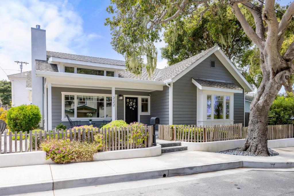 Located just a block from the heart of Lighthouse Ave. and moments from the shimmering shoreline of Lover's Point, this masterfully reimagined Pacific Grove residence is a rare jewel along the Monterey Peninsula. Completely rebuilt from the studs in 2016 and gently lived in since, this single-level 2-bedroom, 2-bathroom coastal cottage offers approximately 1,192 square feet of luxurious living, where timeless charm meets modern sophistication. Step inside to soaring vaulted ceilings, sun-drenched interiors, and rich wood flooring that flows seamlessly throughout. The open-concept great room centers around a stunning chefs kitchen, adorned with sleek quartz countertops, premium KitchenAid stainless steel appliances, a gas cooktop, and an expansive island with seating for four. Just perfect for both everyday living and elegant entertaining. The spa-inspired bathrooms are finished with radiant heated floors and designer touches that elevate daily routines into indulgent experiences. Outside there is a gas fire pit in the front, two paver patios and a stone dog run.
