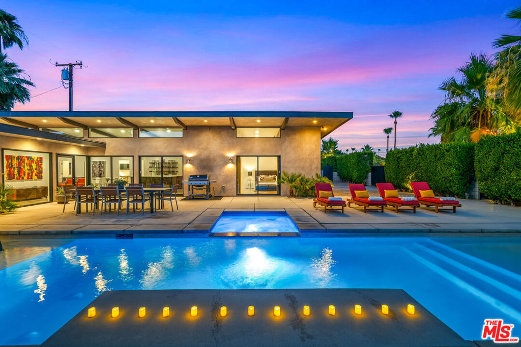 Step into the timeless allure of 2014 Park Drive, a mid-century-inspired architectural masterpiece located in the heart of Palm Springs' coveted Sunrise Park neighborhood. Built in 2015, this gated, newer construction estate captures unobstructed views of Mt. San Jacinto & offers the perfect balance of privacy, sophistication, & resort-style living. Inside, you'll find sleek polished concrete floors, soaring ceilings, & walls of Fleetwood sliders that create seamless indoor-outdoor flow. Large great room is a sun-filled haven designed for entertaining, featuring a chef's kitchen w/ dual Caesarstone islands, stainless steel appliances, & built-in wine cooler all anchored by a striking linear gas fireplace & exposed post-and-beam architecture. Each of the 5 spacious bedrooms includes a private en-suite bath & direct outdoor access, while an attached casita-style suite offers a kitchenette & separate entrance perfect for guests, multi-gen living, or extra rental income. A stylish powder room serves guests. Outdoors, enjoy your own private desert resort: a 42' saltwater pool w/ 2 Baja shelves, spa, 6' waterfall, fire pit, & multiple lounge/dining areas all surrounded by lush desert landscaping & framed by mountain views. Energy-efficient & smartly upgraded, the home includes double-paned windows, Nest-controlled HVAC (3 zones), Lutron Casta lighting, Sonos sound, 2 tankless water heaters, & a Tesla charger. DSCR loan eligible with no personal income verification, this is an ideal investment or luxury retreat. One of the most lucrative short term rental in the nation per AirDNA. Fee simple land you own! The area is well below the cap for getting a new STR permit.