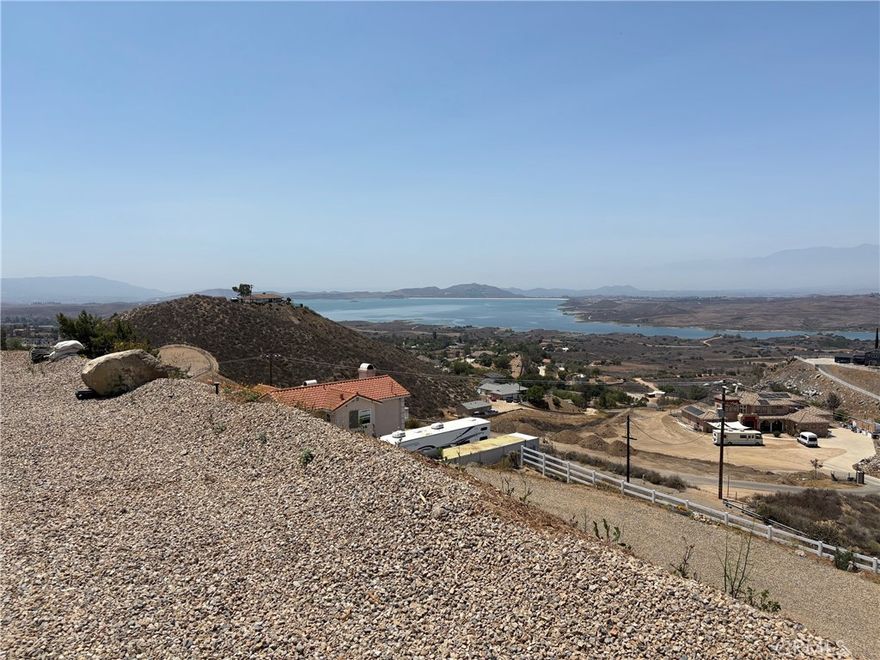 Breathtaking view 2.5 acres building lot. Panoramic view of Lake Mathews, mountains and valleys. You can see for miles. The view is approximately 300 degrees of unobstructed view. This fabulous view lot is ahead of many of the lots for sale, because of the work done by seller. Permits are granted, filled and signed off. This makes months of waiting and work done by seller that would be saved over unimproved lots. Definitely something to consider when planning to build. The lot grading plan and house pad have finalized approval by Riverside County. Water is connected with water meter. Electricity is ready to pull, next to property. The retaining wall is permitted. There is fire truck knockout.  At the top of the lot is a metal carport. The lot is completely fenced with wire fencing and white vinyl fencing at front gate entrance. All the hard work is done!  This lot is ready to build!