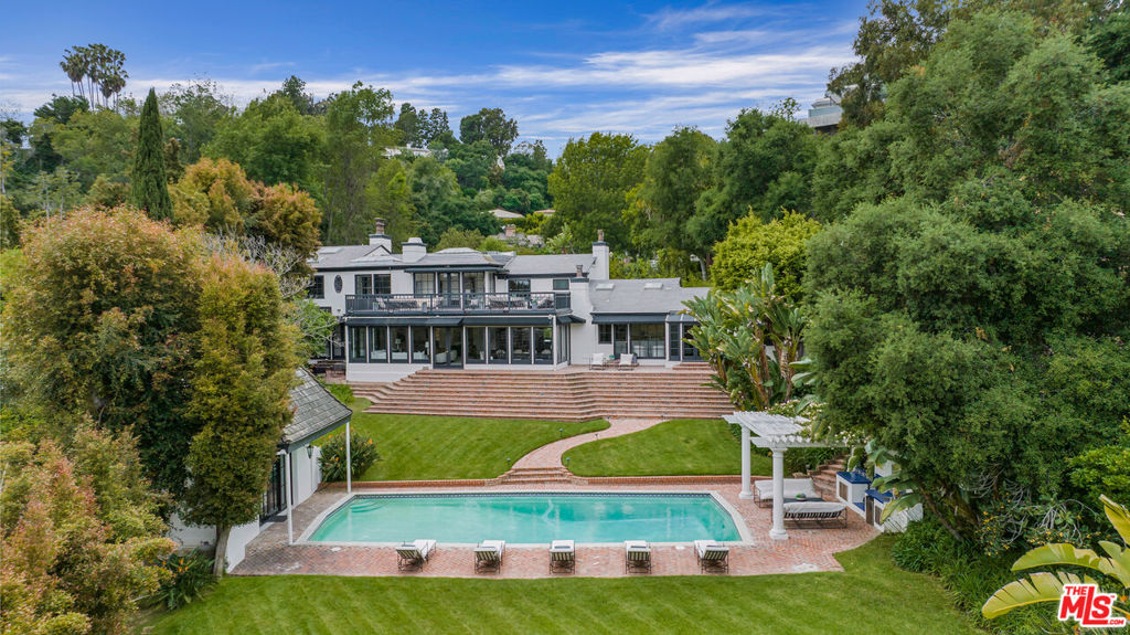 Located in prestigious Lower Bel Air, this exclusive gated estate borders the 15th fairway of Bel Air Country Club, offering lush landscaping and a tranquil lake framed by towering trees. Recently renovated and move-in ready, the 6,200 sq. ft. main residence embodies indoor/outdoor Southern California living with a modern open floor plan perfect for entertaining. Surrounded by estates valued at $50M+, this home offers a rare opportunity at an unbeatable price. It features 4 bedrooms, 6.5 baths, a luxurious primary suite with dual bathrooms and office, a chef's kitchen with Viking and Bosch appliances, and expansive views of the manicured grounds. The property includes a separate pool house/gym with bath, library, a large deck overlooking the oversized pool, and a pool pavilion with fireplace. The nearly one-acre lot provides multiple shaded patios, a vast lawn, and stunning views of the golf course. While move-in ready, there's potential for redevelopment into a 15,000 sq. ft. estate, making this an exceptional investment in one of California's most prestigious areas.