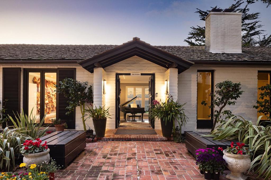 Located in the elevated Carmel Highlands, Villa Fontana-the former estate of Academy Award winning actress Joan Fontaine-is perfectly perched on the hills above the Carmel coastline, boasting sweeping views of the Pacific Ocean and the marine-rich details of Point Lobos. Set on a ~1 acre, Cypress studded lot, the home exudes all the elegance of old Hollywood style and charm, with gallery-like hallways and large entertaining areas. Stunning ocean views can be seen from almost every room and the large, westside decks enable effortless indoor/outdoor living, begging for alfresco dining, morning sunrise coffees, or sunset cocktails. Highlights include a gated entry, 4 bedrooms and 4.5 bathrooms, 4,712 SqFt of light and bright living space, a detached 2-car garage, a golden-era library with cozy fireplace, and open kitchen with unforgettable ocean views. Live like a movie star every day, exploring all the incredible amenities of the Monterey Peninsula, knowing that your private, coastal haven awaits your return.