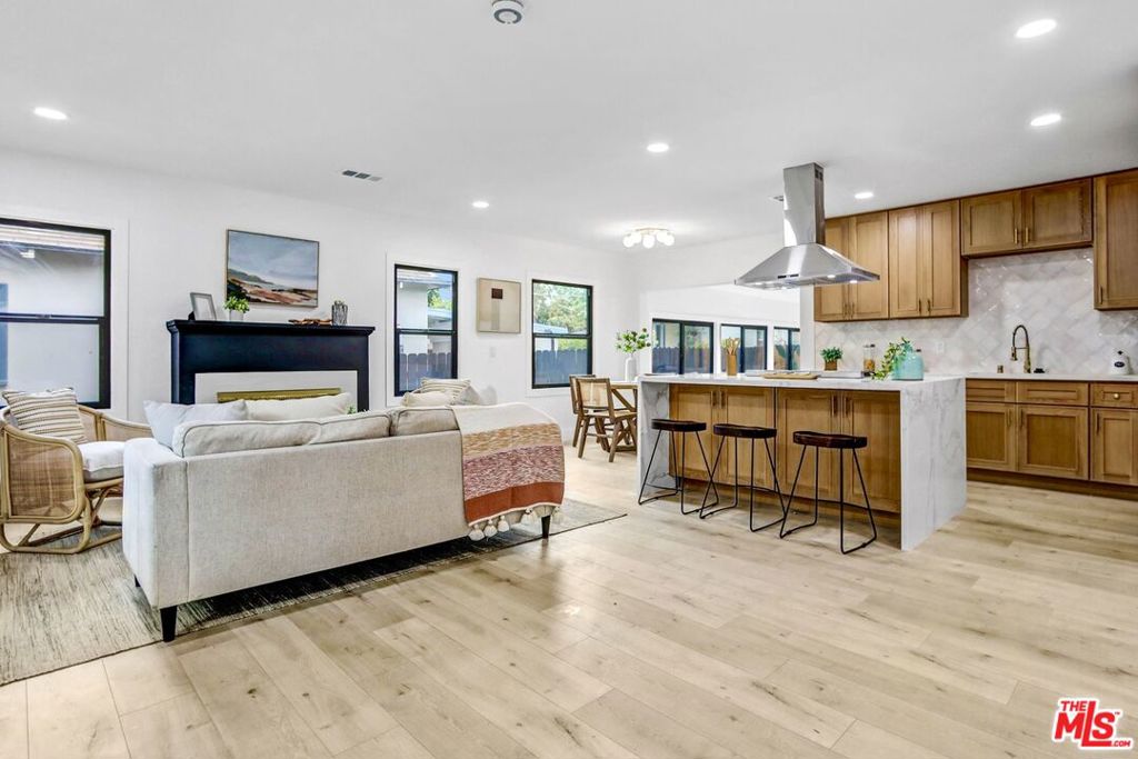 Nestled on a quiet, tree-lined street in one of Pasadena's most peaceful neighborhoods, this beautifully updated single-story home blends timeless charm with modern comfort. Mature trees frame both the front and back yards, providing a lush, tranquil setting with plenty of natural light throughout. Enter into a bright, open-concept layout where the spacious living, dining, and kitchen areas flow together seamlessly, anchored by a sleek fireplace that invites cozy evenings at home. The standout kitchen features a dramatic waterfall island with breakfast bar and pop-up charging stations, premium appliances, abundant cabinetry, and generous counter space, making everyday cooking and entertaining a delight. The expansive living area easily accommodates a large sectional and media setup, with extra room for a reading nook or creative workspace. From here, exit directly out to the private, fenced backyard perfect for outdoor dining, relaxing under the trees, or hosting gatherings with friends and family. The flexible floor plan features two primary suites: one with a walk-in closet, double vanity, and spacious double shower, and the other offering dual closets, peaceful backyard views, and an en-suite bath with a step-in shower. A third bedroom and additional bathroom add versatility for guests, family, or a home office. Thoughtfully remodeled with stylish finishes throughout, this inviting home sits on a generous lot with ample parking, including gated and secure parking for up to four cars, as well as a convenient storage shed, providing comfort, flexibility, and extra outdoor possibilities. There's also potential to add an ADU (Accessory Dwelling Unit) for multigenerational living or rental income. Enjoy this move-in-ready gem near Eaton Canyon, scenic trails, parks, shops, dining, and the Metro Gold Line, the perfect blend of modern living in a desirable Pasadena location.