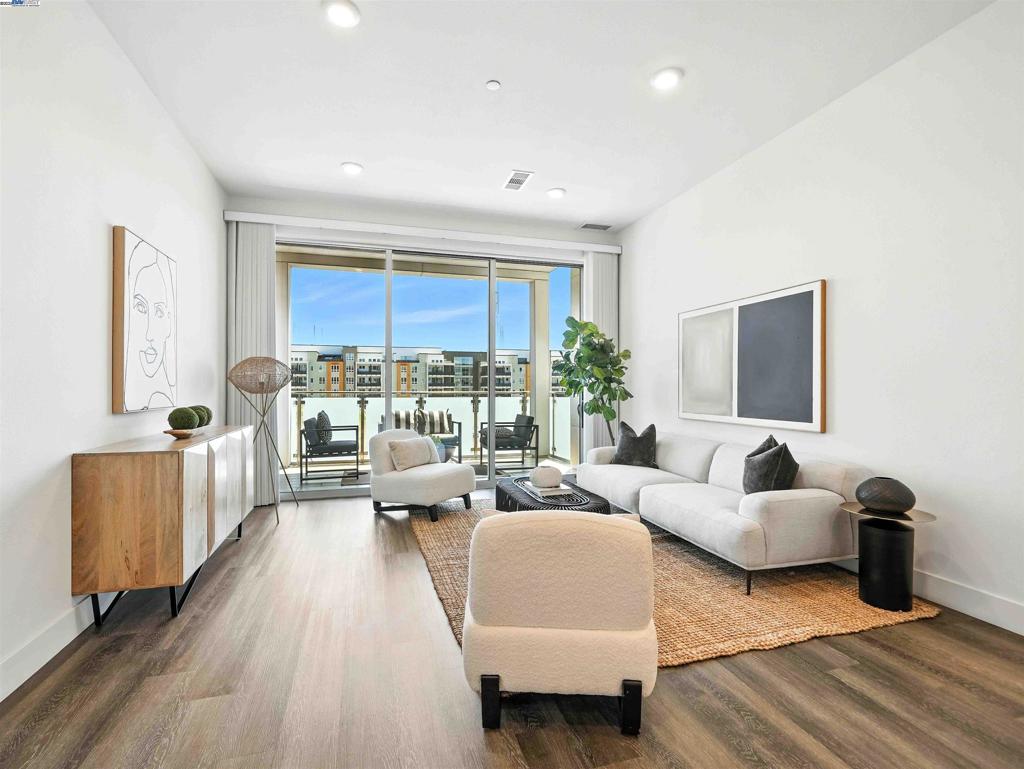 Experience resort-style luxury at Metro Crossing in Fremont, just steps from the BART station. This modern 3-bedroom, 2-bath condo offers 1,524 sq. ft. of open-concept living, $25,000+ modern flooring and counter package upgrades, Grohe dual shower system, Grohe faucets, ring doorbell, and Schlage key pad lock. The home features a spacious kitchen with a large center island, quartz countertops, stainless steel appliances, upgraded backsplash, and extra storage. The kitchen opens to a bright great room with multi-sliding doors that lead to a covered patio, perfect for indoor-outdoor living. The 2-bedroom includes a walk-in closet, and all bedrooms have built-in organizers. The primary suite offers a dual-sink vanity and glass-enclosed shower. Enjoy the convenience of a full laundry room with washer/dryer and central A/C. The HOA includes trash service and exceptional amenities: a gym, pool with cabanas, BBQ area, clubhouse with a full kitchen and pool table, dog wash station, rooftop lounge, bike storage, and two assigned garage parking spots. Additional storage is also available. Located near Pacific Commons shopping and dining, and with easy access to freeways and public transit, this home blends comfort, convenience, and luxury.