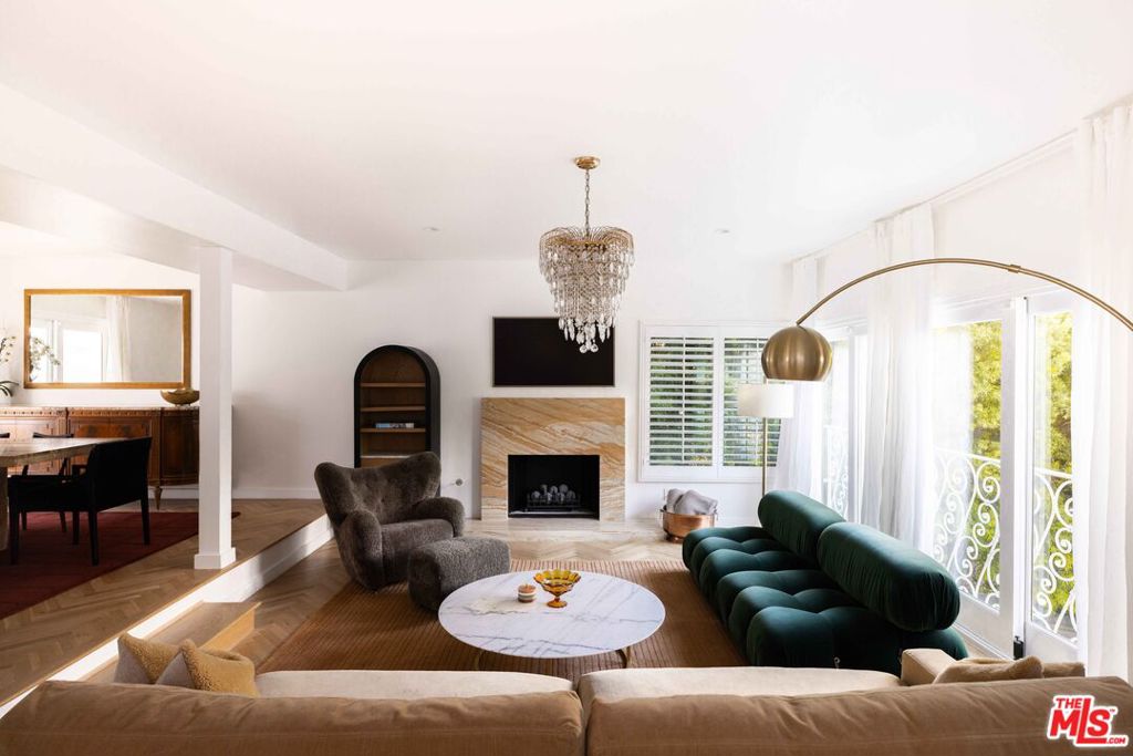 Tucked away in a serene four-home cul-de-sac off San Ysidro Drive, this recently renovated estate offers refined living just minutes from the heart of Beverly Hills. Available fully furnished or unfurnished and thoughtfully equipped, it's truly turnkey for effortless move-in. The main residence captivates with striking curb appeal expansive windows, elegant ivory travertine steps, and custom cream wrought iron accents. Inside, the kitchen makes a dramatic statement with Nero Marquina and Emperador marble in a harlequin pattern, a 9-foot center island with shearling-upholstered barstools, slab marble backsplash, Viking appliances, commercial-grade range, unlacquered brass hardware, and a walk-in pantry. Designed for both comfort and entertaining, the formal dining and living rooms feature a camel-toned quartzite fireplace, full bar, antique hutch, and sliding doors at both ends for seamless indoor-outdoor flow. The powder room offers a moody, jewel-box feel with Nero Marquina and Rojo Alicante marble and an original overmount copper sink. Every space is curated with natural, tactile materials, solid hardwood floors, wool rugs, linen drapery, cotton velvets, boucl, hides, and crystal chandeliers all enveloped in a warm, inviting palette. The primary suite is a true retreat with vaulted ceilings, a marble fireplace, walk-in closet, and a Carrara marble bathroom featuring a clawfoot soaking tub. On the walkout lower level, find terrazzo flooring throughout, a spacious guest bedroom with en-suite bath clad in Calacatta Green, Calacatta Gold, and Picasso Quartzite, plus a full laundry room and access to the attached garage. Outdoors, the private backyard oasis boasts a saltwater pool and spa, ivory travertine patio, Viking grill, and al fresco dining for ten. The guest house is not included in this lease offering and is being offered for lease separately.