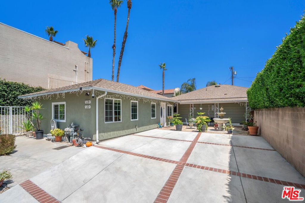 Introducing a charming single-story home tucked away on a quiet cul-de-sac in the heart of Van Nuys. Featuring three bedrooms and two bathrooms, plus a detached 1BD/1BA Accessory Dwelling Unit, this property offers a thoughtful layout, recent updates, and generous outdoor living spaces including a wraparound covered patio. Inside, the living room is filled with natural light and anchored by a cozy gas fireplace, seamlessly connecting to the formal dining area. The kitchen is appointed with stainless steel appliances, abundant cabinetry, a separate backyard entrance, and a dedicated laundry area. Beyond the kitchen, two bedrooms with ample closet space share a recently renovated bathroom showcasing an expansive shower with built-in bench seating. Off of the living room, you'll find an additional full bath and a bright bedroom with a sliding glass door opening to the backyard. The lush and private backyard is perfect for entertaining, with a jacuzzi, a charming garden archway, and a detached studio/flex space with electricity, ideal for an office or gym. The permitted ADU (7130 Mammoth Ave) includes a well-equipped kitchenette with a center island, a living room, a spacious bedroom with a walk-in closet off of the hallway, and a sleek full bath equipped with a step-in shower. A bonus room just off the bedroom provides an ideal space for a home office or creative studio. Additional highlights on the property include a gated driveway, a recently updated roof, and a dedicated, oversized storage room adjacent to the ADU. Conveniently located near local parks, shopping, dining, and commuter routes, welcome!