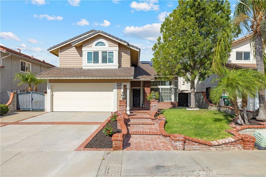 Welcome home to this beautiful property that is located in the Mountainview track in the heart of Saugus! The front yard is beautifully landscaped, featuring a mature peppercorn tree and large date palm trees that provide tranquility with ample shade and dimension. The brick stairway leads past manicured rose bushes to the front door. You are invited into a bright, naturally lit great room with cathedral ceilings and a giant bay window. The open floor plan showcases a gorgeous formal dining area with chair molding, giving a touch of class and sophistication. Through the doorway, you are welcomed to a thoughtfully designed chef’s kitchen that just screams organization and convenience. There is a two-tier lazy Susan in the corner cabinet as well as rolling shelving for smooth and easy access as well as a well appointed small pantry perfect for storing your smaller appliance. There is plenty of counter space for meal preparation and a breakfast bar. The kitchen is open to the family room, where a brick fireplace brings warmth into the home. The large window welcomes natural light throughout the downstairs. The upstairs features four bedrooms and two full bathrooms. The primary room has bright natural lighting and ample loft space for plants or even storage. There are two generously sized closets plus an attached ensuite bathroom. Vinyl flooring is laid throughout the entire upstairs. All four bedrooms have glass rolling closet doors which gives dimension to the space. Bedrooms one & three have loft spaces, and the middle bedroom features gorgeous, whitewashed wood paneling. Walking down the balcony hallway, you will come to find dedicated storage cabinets at the end of the hall with a granite counter. The backyard features a combination of fruit-bearing lemon, lime, and tangerine trees. The uncovered pergola and greenhouse provide great space for the hobby gardener to grow their plants as well as established peppers and herbs for the new owners to enjoy. The lot features plenty of space for all your toys: RV access for a small boat, motorcycle, or jet-skis, plus a storage shed in the backyard for more room to store your items. This property has solar that will be paid off, as well as newer HVAC, Water Heater, and Appliances.