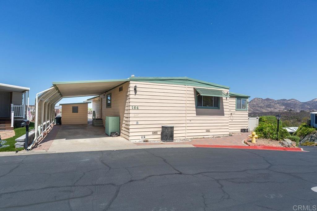 Look at that view! Nestled towards the top of highly desirable Lake Jennings Park Estates on a corner lot, with a stunning view and full vinyl fenced generously sized backyard. Senior park with land ownership and a ton of fun park amenities including pickleball. Two large living areas with tons of natural light to enjoy the mountain, water and evening lights views. The family room has a cozy fireplace. The living room features a wall of windows that highlights one of the best views in the community. The open floorplan and bonus space makes entertaining easy! The kitchen includes all appliances and has ample counter space for cooking and baking. The primary bedroom is large with an added bonus area nook which could be transformed into a great walk-in closet or used as an office, seating, reading or dressing area. The large primary bathroom includes storage and double sinks. The backyard includes a covered patio that leads to a large, fully fenced yard landscaped with drought tolerant plants and pavers. Enjoy morning coffee or happy hour while basking in the beautiful lake view. The carport side includes a large shed. The community amenities include a clubhouse, game room, library, a community pool that is heated year round, jacuzzi tub, sauna, pickleball court, horseshoes, and planned community activities. Easy access to lake trails, fishing and boating. RV parking available. Convenient to the 8 freeway. 55 plus community, one resident can be 45 plus with a 55 plus resident.