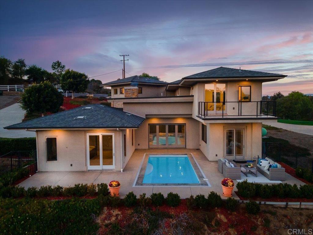 Modern Sophistication Meets Tranquil Fallbrook Living.   Step into a world where modern architecture and natural beauty converge. This contemporary masterpiece in an exclusive gated community in Fallbrook offers 3,642 square feet of sophisticated living, seamlessly blending clean lines, warm materials, and exceptional craftsmanship. Designed to live like a single-story residence, this home offers the perfect balance of luxury, functionality, and privacy — all set in one of North County’s most serene landscapes.  Architectural Design & Flow. The open-concept layout is anchored by dramatic sight lines and expansive glass that blur the boundary between indoors and outdoors. A floating staircase serves as a sculptural centerpiece, leading to the home’s upper-level with potential in-law suite and 3 more bedrooms, while the primary bedroom and all main living spaces reside on the first floor for effortless single-level living.  Andersen pocket doors fully retract into the walls, revealing a spectacular central courtyard with pool and sun-drenched lounging areas creating a private indoor-outdoor sanctuary perfect for entertaining or quiet relaxation.  Luxury Finishes & Details.   Every element of this home was curated with precision and purpose:  Sub-Zero and Thermador appliances, including double ovens and warming drawers, elevate the culinary experience. Restaurant-like pantry with butler's door.  Hansgrohe plumbing fixtures provide refined European design throughout each bath.  The real wood-burning fireplace, also plumbed for gas, offers warmth and ambiance in the great room.  Striking Eleganza tile flooring flows through the interior, adding texture and sophistication.  Every space reflects a commitment to high design, blending functionality with timeless appeal.  Primary Suite & Guest Accommodations.   The first-floor primary suite offers serenity and comfort, featuring direct access to outdoor living areas and poolside tranquility. A private in-law suite provides a perfect retreat for extended family or guests, while additional bedrooms upstairs enjoy exceptional privacy and sweeping views.  Performance & Infrastructure.  Engineered for modern living, the home includes:  A three-car garage (potential for 4 cars) spanning approximately 1,000 square feet, ideal for vehicles and storage, with a pass through garage door to the wrap-around driveway.  A 450-gallon propane tank supporting premium kitchen appliances and energy efficiency.  Two AC condensers for zoned comfort throughout the home.  A well producing 25 gallons per minute with a 2,800-gallon holding tank offering independence and reliability.  Privacy, Comfort & Setting.  Located within a gated enclave of contemporary estates, this residence offers both security and serenity. Thoughtful design ensures every room has a connection to the landscape whether it’s sunlight cascading across the courtyard pool or evening breezes drifting through fully opened walls of glass.  A Statement of Modern Living.   This is more than a home; it’s a lifestyle statement, built for those who appreciate architectural integrity, quality materials, and seamless indoor-outdoor flow. Every space invites you to relax, entertain, and enjoy Fallbrook’s natural beauty in contemporary luxury.  With over 2 acres of land at your avail, there are a plethora of opportunities for the land (ADU, lease to produce company/wine company, etc.) Space for RV, boat.