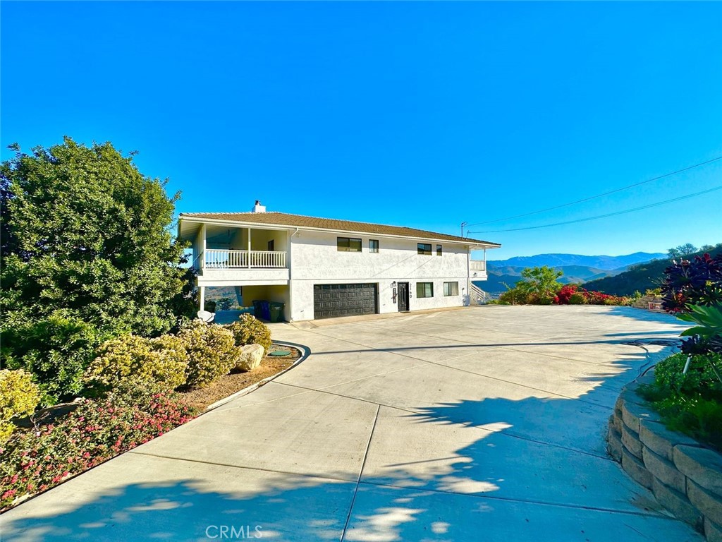 Experience the ultimate retreat on this expansive 9.93-acre property, offering sweeping mountain views from its elevated position above the Pala Mesa Golf Resort and surrounded by lush vineyards. This private and tranquil estate features a spacious two-story home within walking distance to Estate D’lacobelli Winery and Pala Mesa Golf Resort. The upper level includes a comfortable 3-bedroom, 2-bathroom residence with spectacular views, while the lower level offers a spacious 2-bedroom, 1-bathroom guest suite complete with a sleek, modern kitchen and a large family room, perfect for entertaining. The downstairs unit also features a separate entrance, making it ideal for rental income or as a mother-in-law suite. Step outside to enjoy multiple patios that provide stunning views of both the sunrise and sunset. Recent upgrades include a new 50-gallon water heater, a mini-split A/C and heating system, and a newly installed water pump for the well. The property is equipped with a private well, perfect for irrigation, ensuring healthy growth for over 300 avocado trees and 100+ fruit trees, including oranges, limes, lemons, grapefruit, figs, loquats, grapes, pomegranates, and macadamia nuts. A brand-new SOLAR system adds energy efficiency for the home. For ample parking, you’ll find a two-car garage, carport, and additional spaces ideal for storing boats, RVs, or toys. A 3-bay covered workshop, a heart-shaped pond, a WELL and 3-phase 600w electricity enhance the property’s functionality. Access is easy with two separate entrances, one on Puerto Del Mundo and the other on Citrus Dr. This property holds tremendous potential for subdivision to 2 acres per unit, agricultural development such as an avocado farm or vineyard, or even rental opportunities. Located just 5 minutes from Interstate 15 and only 10 miles from Temecula, this property offers convenience and endless possibilities. Don’t let this incredible opportunity slip away!