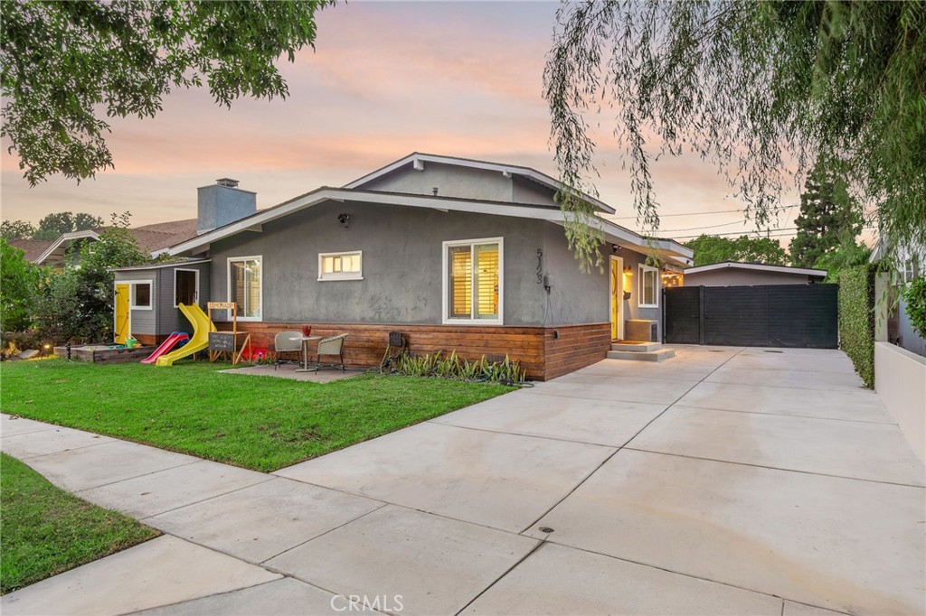 Welcome to 5123 Coralite, an exceptionally spacious and family friendly example of suburban living in a highly desirable neighborhood of Long Beach. Greeted by the matching kids playhouse in the well kept front yard, you make your way down the long private driveway to the matching yellow front door with all you could ask for just steps inside. Once you enter, you'll instantly take in the open concept living space with a spacious dining room to your right, a renovated living room in front of you, and an open concept kitchen to the left which makes for an ideal entertaining and congregating space alike. Just beyond the sliding barn door from the living room landing are two downstairs bedrooms accompanied by a recently renovated full bathroom. Making your way upstairs to the primary en suite, the first thing you may notice is the impressive, vibrant natural light which pairs well with the vaulted ceilings and extra space for a home office. The primary en suite offers room for more than just one, with a walk-in shower, dual vanity and freshly updated finishes in recent years. As if the home itself wasn't enough, you can easily make your way back down through the living room to your custom backyard with everything and anything one may need for those staycations on any given Saturday. With a custom pool and safety netting, low maintenance turf, a built in retractable awning off of the detached two car garage and an outdoor sauna, the only thing missing is the outdoor dinner parties. Fortunately, the custom built overhang off of the driveway behind the privacy gate is draped in strung lighting and paired with a mounted television and built-in gas grill to host those gatherings on warm evenings after a long day in the pool. Equipped with Tesla solar, central AC, an extremely inviting and dynamic floor plan and a list of custom touches, Coralite is ready for the next stewards to enjoy every last bit of.