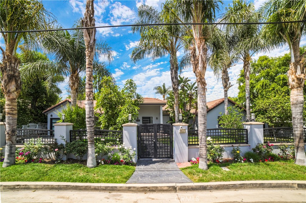 Tucked behind gates on a sprawling, flat lot South of the Boulevard, 19405 Collier Street is a reimagined single-story contemporary estate that captures the essence of upscale Southern California living. From its stunning design to its expansive resort-style grounds, this beautifully remodeled home offers the perfect balance of luxury, comfort, and privacy.
Step into a light-filled, open-concept interior where soaring ceilings, warm wood floors, and custom finishes create an inviting atmosphere throughout nearly 3,600 square feet of thoughtfully designed living space. At the heart of the home, the state-of-the-art kitchen is a culinary masterpiece — complete with a massive center island, sleek quartz countertops, European-style cabinetry, high-end stainless steel appliances, and an oversized walk-in pantry. Whether you're preparing a quiet dinner or hosting a crowd, this kitchen was made to impress.
Retreat to the exceptional primary suite featuring French doors to the backyard, a walk-in closet, and a spa-inspired ensuite bath with a luxurious multi-head walk-in shower. The home’s seamless flow and no interior steps add to its functionality and ease of living.
Step outside and discover your own private oasis: a sparkling pool, outdoor kitchen, and a generous grassy area ideal for entertaining, relaxing, or enjoying sunny Tarzana afternoons. Designed for both quiet moments and lively gatherings, the backyard delivers the true indoor-outdoor lifestyle.