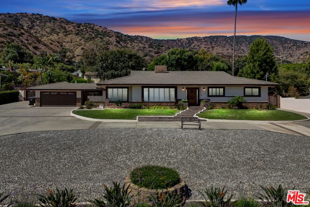 Welcome to 1025 W. Sierra Madre Ave, a single-story Glendora gem set on a rare half-acre lot (21,567 sq. ft.). This 3-bedroom, 3-bath home also features a den and bonus room, offering plenty of flexible living space. As you drive up the expanded driveway perfect for RV parking or even a covered carport you'll immediately notice the stunning views stretching across the Las Colinas and Rosedale communities all the way to the historic Dhammakaya Temple. Step through the southern-facing front door into a bright, open floor plan highlighted by crown molding, chestnut hardwood floors, and a welcoming living room with a stone fireplace. Fresh comfort abounds with a brand-new central AC system and two brand new water heaters. The dining area captures panoramic views, while the kitchen offers brown maple wood floors, abundant cabinetry, and a breakfast bar that flows into the den, complete with beamed ceilings and a second fireplace. The oversized primary suite is a retreat of its own, with serene pool views and a spa-like en-suite bath. Outdoors, your private oasis awaits a 10-foot Olympic-style pool with diving board, outdoor shower, and a covered patio. The spacious lot also provides potential for an ADU, making it ideal for extended living or investment. With an attached 2-car garage and extended parking for all your guests and close proximity to top schools such as St. Lucy's Catholic School, great parks, and shopping, this turnkey home combines lifestyle, location, and luxury in one rare find.