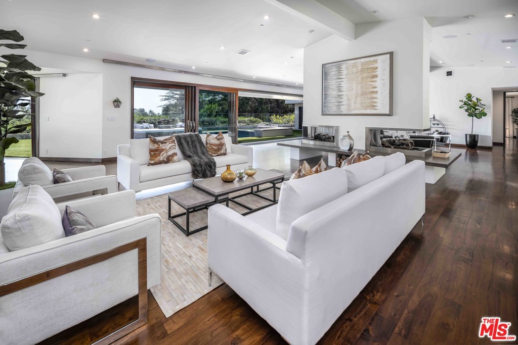 This gated, mid-Century modern estate located in prime Trousdale Estates features glittering views of Los Angeles. The expansive living and family room share a double-sided fireplace and leads into a formal dining room, surrounded by Fleetwood sliding doors. The extraordinary gourmet kitchen is designed with carrara marble counters with Wolf stainless steel appliances. Entertain in the enchanting backyard with twinkling night lights, pool, spa, firepits, and built-in barbeque. Three bedrooms are en-suite and in the master suite, a romantic fireplace, gorgeous master bath with soaking tub, and gym/meditation room provides maximum privacy and serenity. Just freshly painted, this home is move-in ready. Broker/Agents and Seller do not guarantee accuracy of square footage, lot size, zoning, rent control, permits, use code, regulations, schools and/or any other information concerning the property. Buyer is advised to independently verify the accuracy of all information through personal inspections/investigations.