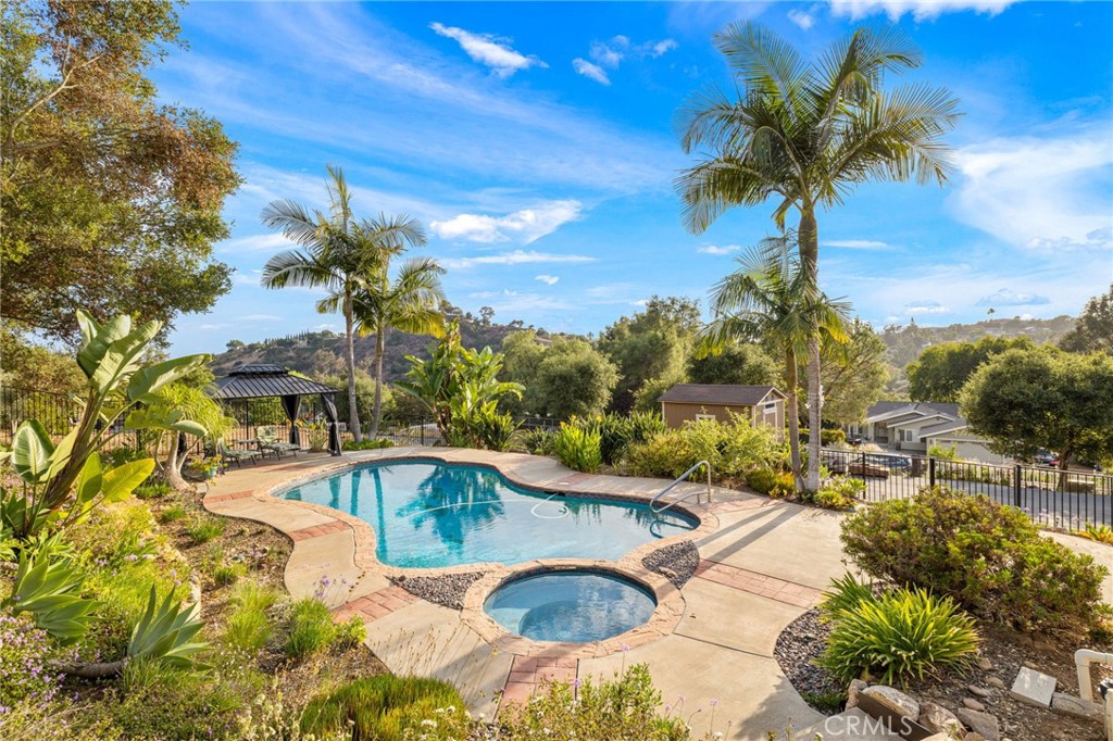 Set on 1.33 acres, this Fallbrook ranch retreat blends timeless tradition with modern comfort. Elevated among oak trees with sweeping views, the 2,589 sq ft single-story layout offers 3 bedrooms plus a spacious office/bonus room, a private primary suite with updated shower and walk-in closet, and secondary bedrooms with custom closets and barn-style doors. The inviting kitchen features concrete countertops and a breakfast bar. Outdoor living shines with a sparkling saltwater pool and spa (with new pool vacuum), expansive decks, extra fencing ready to re-establish horse facilities or create a garden, a greenhouse, and a 3-car garage. Modern conveniences include WiFi-controlled automatic sprinklers, a smart garage door remote, whole-house water filtration, newer HVAC, whole-house fan, gutters, and a Tuff Shed.