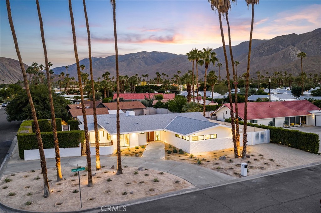 This 1959 mid century newly designed home in sought-after South Palm Springs is waiting for its new owners after being transformed! Enter through the wood front door and enter your large living room with fireplace, high ceilings, and aluminum bi-fold doors across the back of the living room leading you to the backyard where you will be greeted with a fully remodeled pool, backyard, and large covered patio to enjoy the outdoors and mountain views. Off the pool area is a large primary suite with a large walk in closet, a primary bathroom offering a curbless walk in shower, and separate soaking tub. On the other side of the home you will have the privacy of 3 additional bedrooms including one more primary suite with a walk in closet and curbless entry shower. The kitchen boast of frameless soft close cabinets, quartz countertops, and Z Line appliances. The home offers tons of natural light through the new construction aluminum double pane windows. The main home offers a powder room for guest and an additional bathroom with curbless shower for the additional guest and bedrooms. A private separate laundry room. This home combines mid century bones with updated organic modern design and earthy tones. The home offers Tesla paid off Solar, No land lease, privacy of a corner lot on a cul-de-sac, new roof, new HVAC, new plumbing, new electrical, new landscape and sprinklers, and so much more. Just minutes from downtown Palm Springs, Shopping, and Dining. Make this home a permanent residence, secondary home, or rental. Don't miss this opportunity to own this modern gem.