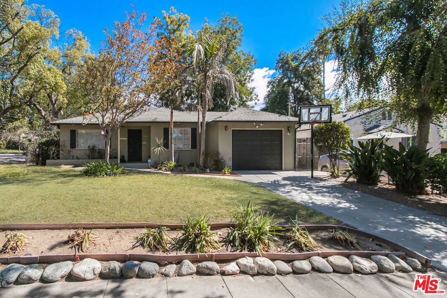 Set on a picture-perfect, tree-lined street in highly desirable Pasadena, this lovely mid-century home offers 2 bedrooms and 2 full bathrooms. The interior features hardwood and slate flooring throughout, original windows, and an open sunroom that connects to a tranquil backyard with a soothing fountain and covered patio ideal for entertaining or relaxing. The cozy kitchen boasts wood countertops, a hammered copper farmhouse sink, pantry, dishwasher and additional copper prep sink. The spacious primary suite includes a skylight, jacuzzi tub, slate flooring, and vanity with a copper vessel sink. Additional highlights include central air and heat, an attached one-car garage, and a charming fenced backyard perfect for outdoor dining or enjoying peaceful nights under the stars in your private jacuzzi.