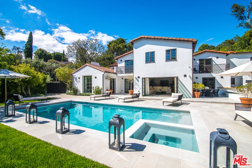 Located on celebrity-studded Tower Road in Beverly Hills, this exquisitely reimagined home blends traditional Spanish Colonial architecture and clean, contemporary design. Off an elegant entryway, a living room with a fireplace and exposed beam ceiling leads to an open great room lined with folding glass doors that foster an effortless indoor-outdoor connection. A formal dining area flows to an exceptional chef's kitchen with Wolf appliances, walk-in pantry and wine room, while an ensuite bedroom is ideal for an office. The second level holds three junior suites replete with ensuite baths and walk-in closets. French doors off the master suite open to a private balcony, while a Calacatta marble bathroom and dual showroom closets elevate the offering. A fully hedged, grassy backyard features a pool, spa, fire pit, elevated terrace and built-in bbq area. The latest smart home tech completes this harmonious retreat, moments from the best shops and restaurants in Beverly Hills.