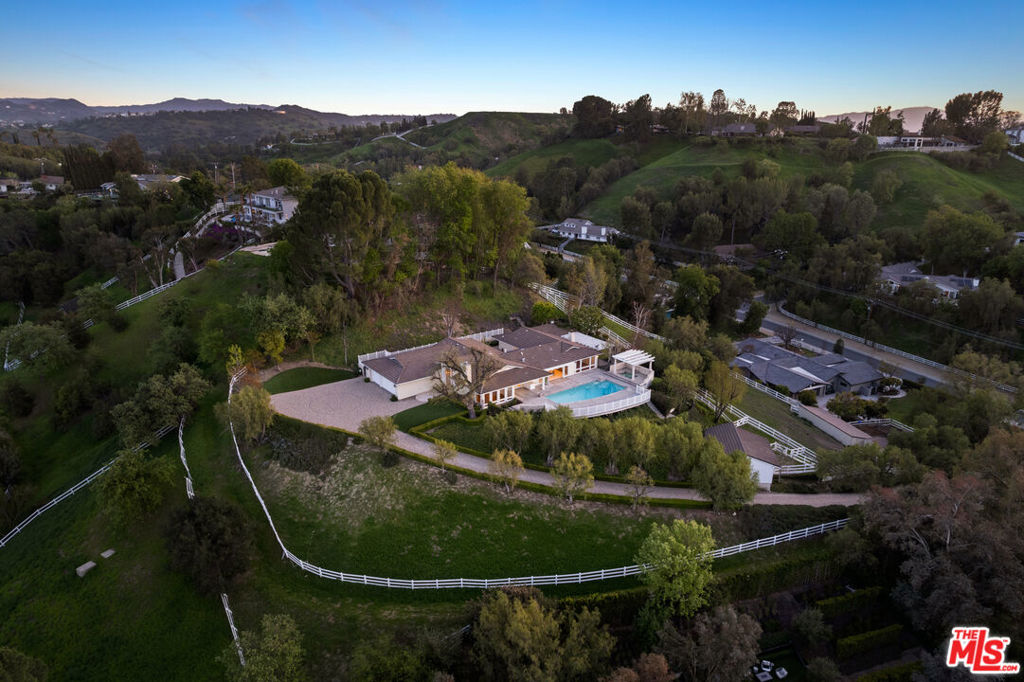Welcome to your sanctuary where privacy and serenity seamlessly blend to create an exceptional haven. Rare opportunity to live in Hidden Hills at this price point and customize your dream home. Nestled atop a long, private driveway, this single-story residence sits on a secluded hilltop, offering breathtaking 240-degree views of the Upper Las Virgenes Canyon Open Space Preserve, the picturesque valley, and rolling hills. Step outside to discover an entertainer's utopia where an expansive pool and spa provide an opulent retreat for relaxation amidst the beauty of the natural landscape. At its heart, the gourmet kitchen boasts a center island and top-of-the-line stainless steel appliances - perfect for culinary enthusiasts. The living room, dining room, and family room are thoughtfully designed with expansive windows and doors that open to the outdoors, framing stunning views and filling each space with an abundance of natural light. The primary suite occupies its own wing for peace and tranquility, while three additional bedrooms are located on the opposite side of the house. For those who crave privacy, this tranquil residence awaits.