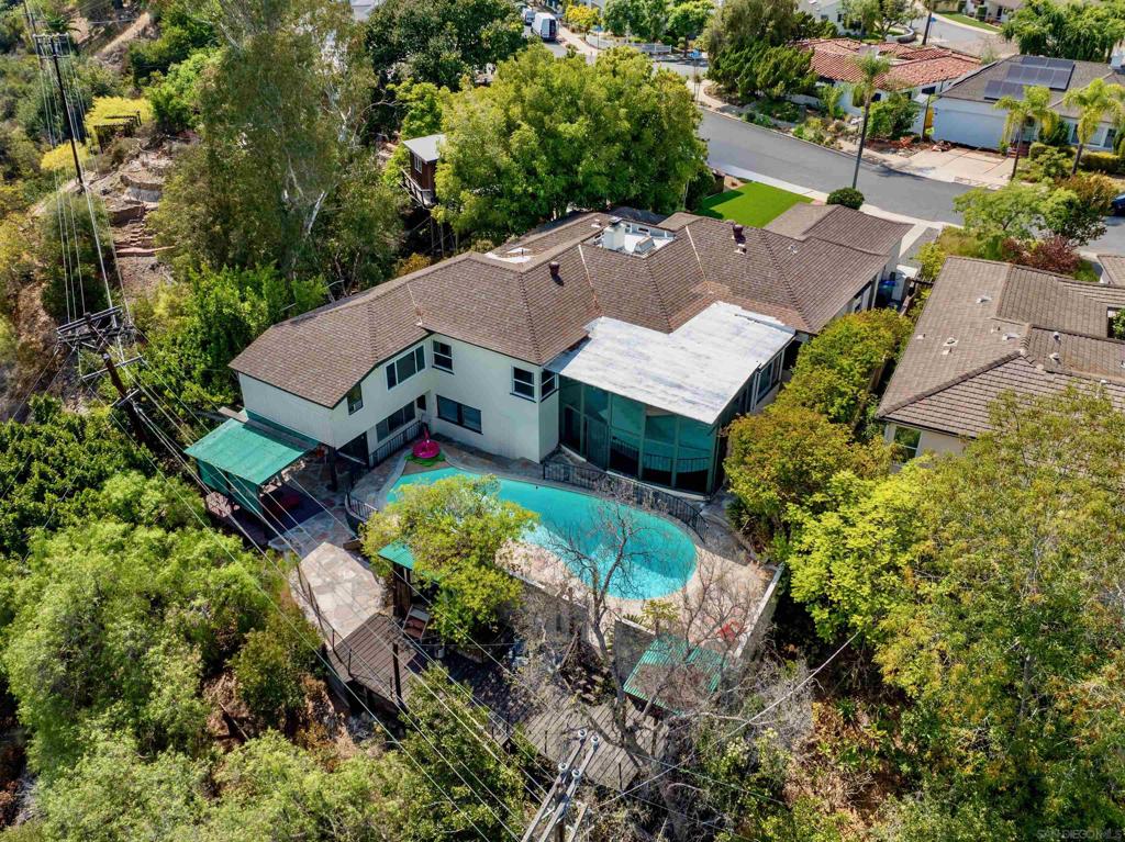 Nestled in the heart of one of San Diego’s most sought-after neighborhoods, this extraordinary residence in Kensington offers the rare combination of classic charm, modern upgrades, and unmatched space. Situated on an exceptional half-acre canyon lot, this 5-bedroom, 3.5-bath home, with two additional optional bedrooms, boasts over 3,222 square feet of thoughtfully designed living space. Step through the grand foyer and into a world where timeless architecture meets contemporary elegance. The recently renovated chef’s kitchen is the true heart of the home, an entertainer’s dream equipped with premium finishes and designed to impress even the most discerning culinary enthusiast. Modern upgrades extend throughout the home, including an upgraded 200 AMP electrical system and 4 zoned air systems offering both safety and energy efficiency for years to come. Designed with flexibility and function in mind, the home’s layout flows effortlessly across two levels. Downstairs, two generously sized rooms are complete with a private entrance, kitchenette, and full bath, offering a self-sufficient retreat perfect for multi-generational living, a guest suite, or even a lucrative rental opportunity. Step outside and experience the quintessential Southern California lifestyle: a sparkling private pool, serene canyon views, and expansive outdoor patios that invite you to unwind, entertain, and enjoy year-round sunshine. And when it’s time to explore, you’re just a short stroll from vibrant Adams Avenue, home to beloved cafés, eateries, and the iconic Mission Brewery.