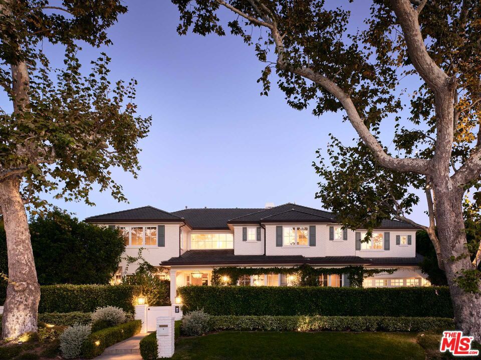 Sitting on completely hedged grounds in the Lower Riviera, this Traditional Cape Cod Estate combines quality craftmanship with inviting warmth. Since completion, the property has been re-envisioned to incorporate new design elements, upgrades & finishes. Upon entering chevron floors define the foyer, which is flanked by the formal dining and living room. Enjoy indoor / outdoor California living at its finest with accordion style doors that open to multiple private patios, an outdoor kitchen, pool, spa, & large grassy area. The open chef's kitchen is flooded with natural light and boasts dual sinks and dishwashers, honed single slab marble countertops & backsplash, Wolf & Sub-Zero appliances, plus a massive walk-in pantry. A designer appointed wet bar is conveniently set between the kitchen and family room, perfect for entertaining! The main floor is complete with a large office, guest bedroom & en-suite bathroom, powder room, butler's pantry, and direct garage access. All 4 bedrooms upstairs are fit with vaulted ceilings and en-suite bathrooms. Within the primary suite, enjoy custom blackout shades, a seating area, oversized walk-in closet, and direct access to an additional flex room that could be a perfect second closet. The primary bathroom is equipped with a steam shower, soaking tub, heated floors, and dual vanities & water closets. The basement features an oversized movie theatre, gym with Barre & heated floors, temperature regulated wine room, guest bedroom with en-suite bathroom and an additional powder room. Each bathroom is appointed with heated floors and custom marble finishes. This home runs on a Savant system with Lutron lighting & blinds, an electric pool cover, and retractable awnings.