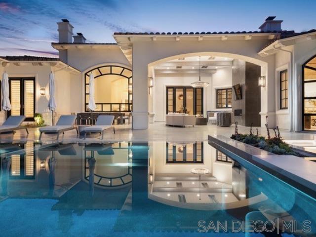 SUBLIME EXCELLENCE ~ Set on one of the most sought after sites in this prestigious, guard gated community. This custom-built Single-Level Estate sits on one of the Most Coveted west-side VIEW parcels & set on the 15th green, framing Panoramic Golf Course with total privacy. A dramatic sense of arrival and timeless design enriched by modern elements, abundant natural light, and a seamless indoor-outdoor flow, elevate everyday living into a Resort-Inspired experience. Ideal open-concept floor plan with 5BR Suites, a dedicated library, Guest House, temperature-controlled Wine Room, and a sleek Wet Bar. Custom limestone floors, DuChâteau wire-brushed oak flooring, designer fixtures, and polished nickel hardware add warmth and sophistication. The top designer gourmet chef’s kitchen is a true statement piece, anchored by a large marble island, custom cabinetry, Sub-Zero, and professional-grade appliances, hooded range and premium hardware. The primary suite is a Private Sanctuary, filled with natural light and peaceful views. The spa-inspired bath features white marble countertops, dual vanities, a large walk-in shower, soaking tub, and a massive boutique-style walk-in closet. Enjoy resort-style amenities like a Floating Fire Pit Lounge over water, wet-edge pool, a full Summer Kitchen with farm sink and grill, and layered patios surrounded by lush landscaping and views. Perfect as a primary residence or luxury vacation home, this move-in ready estate is located just minutes from Del Mar’s world-class beaches, top-rated schools, and all that San Diego luxury living has to offer.