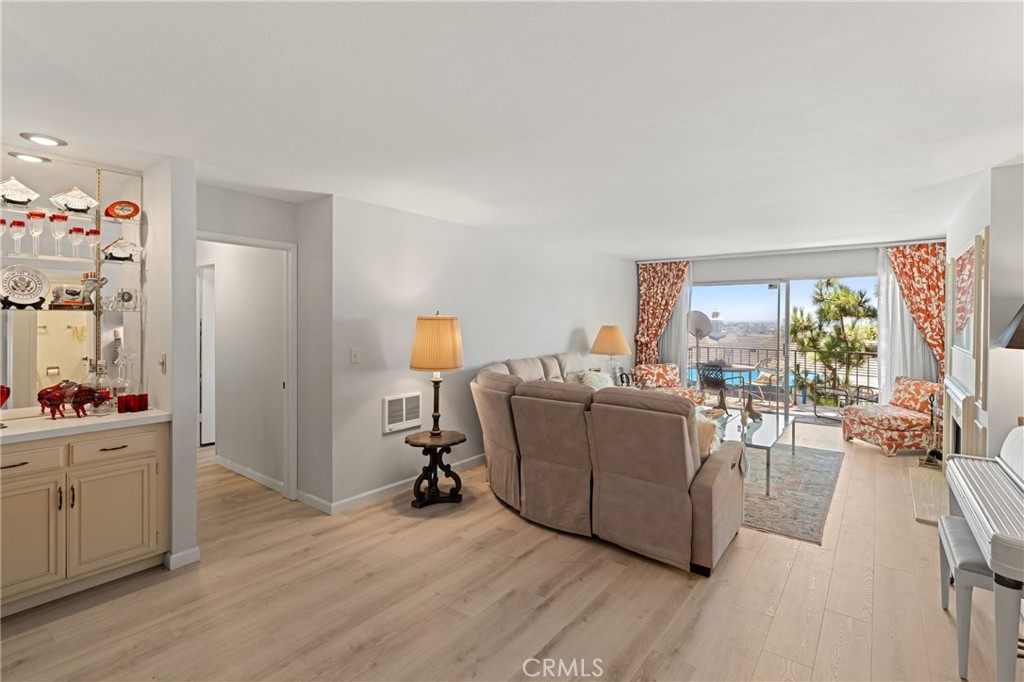 On the market for the first time in nearly 50 years, this 2 bedroom, 2 bath home in the gated Versailles community offers one of the most desirable locations in the 101 building. Positioned at its center, the home enjoys sweeping views of the ocean, harbor, Catalina, and city lights from nearly every room. A private balcony off the living room welcomes refreshing ocean breezes, with a cozy fireplace that adds warmth and charm to the interior. The open floor plan features a spacious living and dining area connected to the kitchen, complemented by new faux-wood flooring throughout the home. Recent improvements include smooth ceilings in most rooms, updated wall finishes, upgraded door hardware, and a remodeled primary bath water closet. The majority of the home reflects meaningful updates while offering the perfect opportunity to design a personalized coastal retreat. Resort-style amenities including a pool, spa, clubhouse, fitness center, and sauna enhance the lifestyle. Just minutes from Balboa Peninsula’s beaches, shops, and dining, this rare offering combines location, views, and potential in one.