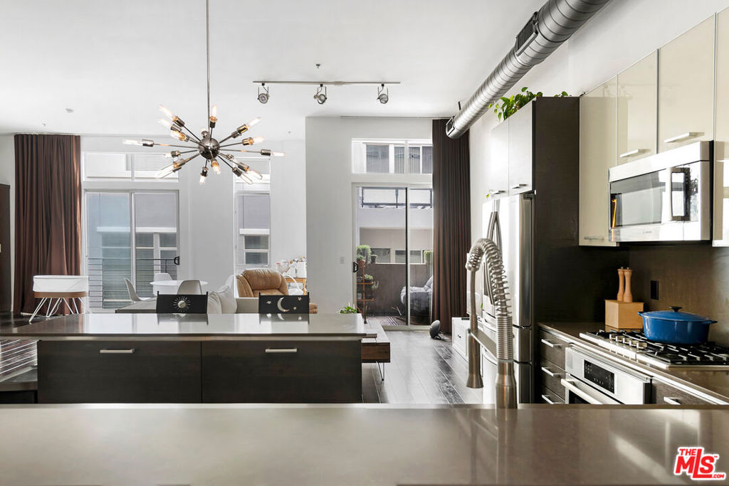 Discover this modern & expansive loft in the sought-after boutique Steel Lofts building. This architecturally distinctive and intimate community is ideally located just minutes from the beach, Abbot Kinney, and a vibrant array of dining, shopping, and entertainment destinations. Situated on the third floor, this thoughtfully designed residence showcases soaring ceilings, floor-to-ceiling windows that bathe the interior in natural light, and rich hardwood floors throughout. The open and flexible layout offers the option to configure the space as two bedrooms or as a one-bedroom plus den, providing versatility to suit your lifestyle. The chef's kitchen stands out with its sleek finishes, generous island, and ample cabinetry perfect for both everyday living and entertaining. Additional highlights include in-unit laundry, abundant storage, and two dedicated parking spaces with plenty of guest parking available.With low HOA dues and a tranquil setting moments from the lively energy of the Marina, this home offers the ideal combination of coastal calm and urban convenience.