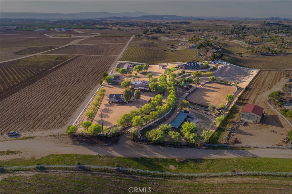 One-of-a-Kind Luxury Estate & Horse Ranch in Temecula Wine Country.
Welcome to the most amazing & truly special property in all of Temecula Wine Country—an exceptional estate set on over 7+ pristine acres, backing to miles of vineyards. 3 private homes, premier equestrian facilities, & resort-style amenities, this estate is a rare gem. Whether you're planning a luxurious retreat, establishing a multi-generational family compound, or looking for an income-producing vacation rental, this property offers it all.
Estate Highlights: Multiple Homes for ultimate flexibility & privacy.
Impeccably landscaped grounds w/resort-style lagoon pool & spa, panoramic vineyard views, & many entertaining spaces.
Top-tier horse facilities including a lighted riding arena. Expansive 225’ x 125’ with lights & speakers, perfect for training and events, viewing pavilion, 15 Horse Mare Motel: Open-air stalls of varying sizes w/a minimum of 18’ x 20’+, 60' round pen, wash racks & tack room.
Located just minutes from Temecula’s world-renowned wineries, shopping & freeway access.
The Main Residence: Tuscan-inspired & beautifully appointed with 4 bdrm's, 2 luxurious master suites w/spa-style baths & walk-in closets. Open-concept living w/retractable bi-fold patio doors for true indoor-outdoor living.
Chef’s kitchen w/Viking stainless appliances, custom wood cabinetry, 8’ butcher block island, & leathered granite countertops. Walk-in pantry w/built-in wine cooler. Natural stone floors & custom ambient lighting thru out.
The Villas: Nestled in the heart of the estate, the Villas feature a rustic inn ambiance w/stunning stonework & scenic views of gentle hills. Each villa offers: 4 private suites w/a shared lobby space. Each villa offers a King bed, electric fireplaces, smart TVs, mini-refrigerators & coffee/espresso machines. Bathrooms w/large stone showers, dual sinks, & separate water closets.
The Cottage is darling includes: 2 bdrm's & 2 baths, Full kitchen & cozy living area. Indoor & outdoor dining spaces perfect for relaxing or entertaining. Decorated w/upscale rustic ranch flair & equipped with every amenity for a pampered, unplugged experience. So Many Possibilities. Perfect for multi-family stays, destination events, equestrian vacations, or a dream home with income potential. This estate is more than a property—it’s a lifestyle destination. Truly a magical property & is turnkey.  This is a must see!!