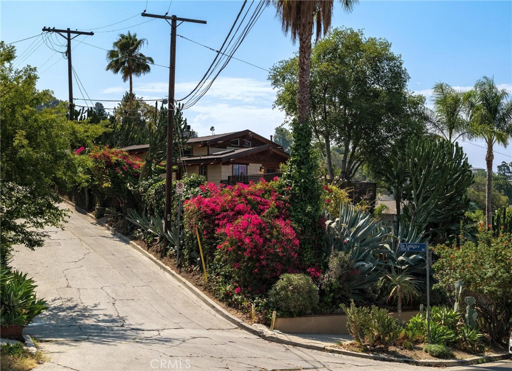 Offered for the first time in almost 50 years, this is an architectural gem located in the coveted Franklin Hills of Los Feliz. A one-of-a-kind true craftsman home, inspired by the iconic Gamble House and architects Greene and Greene, offers privacy, views, unmatched character and impeccable craftsmanship. Upon entering you are surrounded by decades of mature growth and varieties of beautiful succulents and towering cacti. Built with the highest quality of materials in every detail, with solid oak, douglas fir, and redwood throughout. Diagonal oak hardwood floors warm the house, while handmade solid douglas fir doors with hammered bronze knobs, tie the house together. The living room is anchored by a river rock fireplace, while stained glass art fixtures and artistic tile reliefs add rich detail throughout. Natural light floods the house throughout the day. Slate stone floors welcome you into the bathroom comprised of hand-crafted tiles, a clawfoot tub, and a multi-showerhead walk-in with brass fixtures. Some additional features for modern comfort include central heat and AC. Closets lined with pristine cedar planks, storage nooks, and Elfa shelving. A second bedroom offers a large walk-in closet with plumbing for a potential second bathroom. The exterior of this magnificent home displays impressive woodworking craftsmanship, hardy board siding, and copper gutters and downspouts. Up on the chimney sits the vigilant owl, perched to keep watch over this jewel of a home. Enjoy city and sunset views from the wrap-around wooden deck, or soak in the jacuzzi under the trees. A newly constructed retaining wall, with 4 foot diameter pylons drilled 19 feet deep, provides structural integrity and peace of mind. The detached two car garage reflects the same level of artisanal detail as the main residence, with custom high length wood beams, both beautiful aesthetically, and structurally sound. Walkability to
restaurants, night life, grocery stores and Sunset Junction. Perched high above the street for ultimate privacy, yet minutes from Griffith Observatory, The Greek Theater, Hollywood Bowl, and countless restaurants and cultural hotspots. This is a once in a generation opportunity to own an irreplaceable piece of Los Angeles history, one which could never be replicated today.