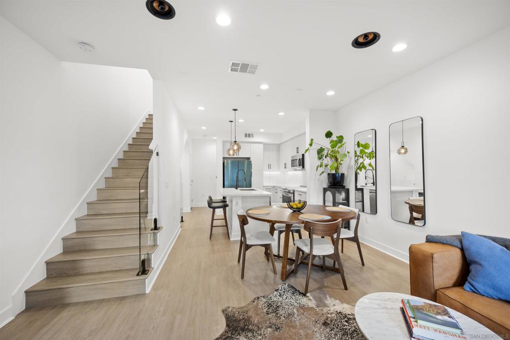 Welcome to 7621 University Ave, Unit 102 a modern, move-in-ready townhouse offering the perfect blend of style, functionality, and location. With 3 full bedrooms and 3 full bathrooms, this thoughtfully designed home showcases sleek upgrades and contemporary living just minutes from vibrant downtown La Mesa. Step inside to discover a bright, open-concept layout featuring luxury vinyl plank (LVP) flooring throughout, sleek modern glass railings that visually open up the space, and built-in ceiling surround-sound speakers for an elevated entertainment experience. The spacious living and dining areas flow effortlessly into a modern kitchen with stainless steel appliances and plenty of prep space ideal for gatherings or quiet nights in. Smart details continue throughout, including a custom-built nook that makes the perfect dog living space or coffee/dry bar, adding both charm and versatility. Upstairs, the primary and second bedrooms each feature private bathrooms, offering comfort and privacy for every household member. The primary suite includes a small walk-in closet and a large shower with a built-in bench and bottle enclave, designed for everyday luxury. The third bedroom and full bathroom are conveniently located on the main level, ideal for guests or a home office. Enjoy your own private, turfed patio with planter boxes perfect for creating a cozy outdoor retreat or growing a small home garden. The two-car garage offers secure parking and extra storage, while the low-maintenance community allows you to fully enjoy the best of La Mesa living without the upkeep. OWNED SOLAR