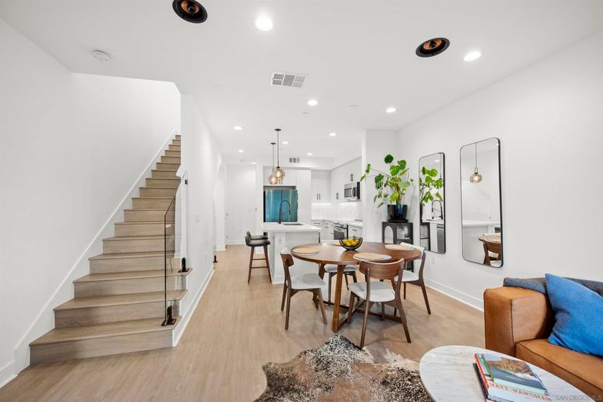 Welcome to 7621 University Ave, Unit 102 a modern, move-in-ready townhouse offering the perfect blend of style, functionality, and location. With 3 full bedrooms and 3 full bathrooms, this thoughtfully designed home showcases sleek upgrades and contemporary living just minutes from vibrant downtown La Mesa. Step inside to discover a bright, open-concept layout featuring luxury vinyl plank (LVP) flooring throughout, sleek modern glass railings that visually open up the space, and built-in ceiling surround-sound speakers for an elevated entertainment experience. The spacious living and dining areas flow effortlessly into a modern kitchen with stainless steel appliances and plenty of prep space ideal for gatherings or quiet nights in. Smart details continue throughout, including a custom-built nook that makes the perfect dog living space or coffee/dry bar, adding both charm and versatility. Upstairs, the primary and second bedrooms each feature private bathrooms, offering comfort and privacy for every household member. The primary suite includes a small walk-in closet and a large shower with a built-in bench and bottle enclave, designed for everyday luxury. The third bedroom and full bathroom are conveniently located on the main level, ideal for guests or a home office. Enjoy your own private, turfed patio with planter boxes perfect for creating a cozy outdoor retreat or growing a small home garden. The two-car garage offers secure parking and extra storage, while the low-maintenance community allows you to fully enjoy the best of La Mesa living without the upkeep. OWNED SOLAR