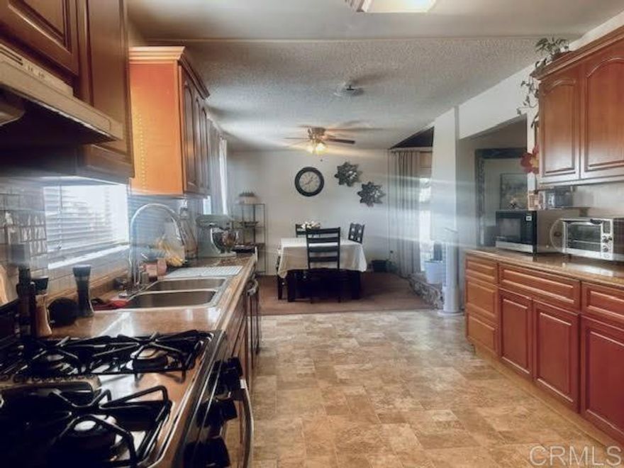 This is it! - Your opportunity to live in a fantastic La Mesa Neighborhood without the price-tag! Your forever home with a forever view. Spacious single-story La Mesa home offering beautiful panoramic views and an open floor plan with endless potential. Located on a quiet street with just minutes to freeways, the trolley station, schools, a neighborhood park, Grossmont shopping, restaurants, gyms, and more. Featuring a large open living area with a step-up design that flows into the dining room. At the heart of the home is a circular fireplace that connects the den, dining area, kitchen, and living room, creating an inclusive and inviting space for gatherings. The den features a beautiful wood-beamed ceiling and a sliding door that opens directly to the yard. The kitchen is generously sized with plenty of cabinet space. There is a separate laundry room off the kitchen for your convenience. The bedrooms are a great size, and the center hallway features a large coat closet and a separate linen closet for additional storage. The living room skylight adds natural light, and ceiling fans throughout provide comfort on hot summer days. You’ll love the breezeway entry leading to a fully fenced yard, offering both privacy and security. This beauty with endless possibilities does need some TLC. Its open layout, character features, and unbeatable location make it an obvious choice.