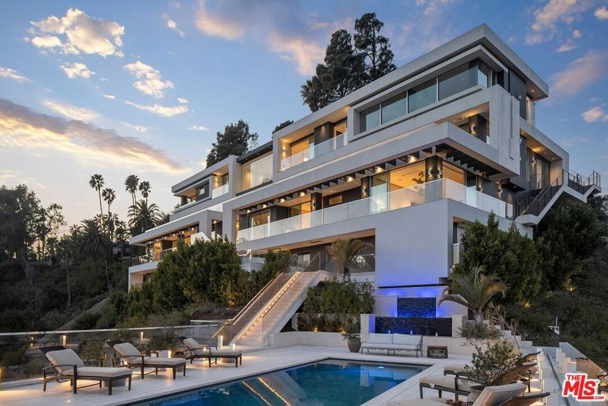 Tucked away at the end of a private road off prestigious Bel Air Road, this exceptional contemporary estate offers sweeping jetliner views over the city lights, set on 5.5 acres of meticulously curated land. Spanning nearly 13,000 sq. ft. of finely crafted living space, the residence is a masterclass in construction and design, showcasing the highest standards of sophistication, luxury, and quality with a steel and concrete structure. Expansive floor-to-ceiling glass doors effortlessly disappear, creating a seamless transition between the interior and the meticulously landscaped outdoor areas, with panoramic views stretching from the hills and downtown LA to the California coastline. This extraordinary residence features 6 generously appointed bedrooms and 12 exquisitely finished bathrooms, with an array of refined living spaces. A state-of-the-art kitchen is a chef's dream, outfitted with the finest appliances and accompanied by a separate catering kitchen. The outdoor oasis is replete with an swimmer's pool, spa, BBQ area, dining space, tranquil water features, and cozy outdoor fireplaces - perfect for simple relaxation or entertaining on the grandest scale. Amenities includes a gym with tranquil sauna, wine cellar with 320 bottle capacity, private walk-in safe, a museum-quality garage with panoramic views, elevator, 15 foot screening wall, and cutting-edge smart home technology throughout. A rare opportunity to own an estate of unparalleled craftsmanship, situated in one of Los Angeles' most coveted and secluded locations.
