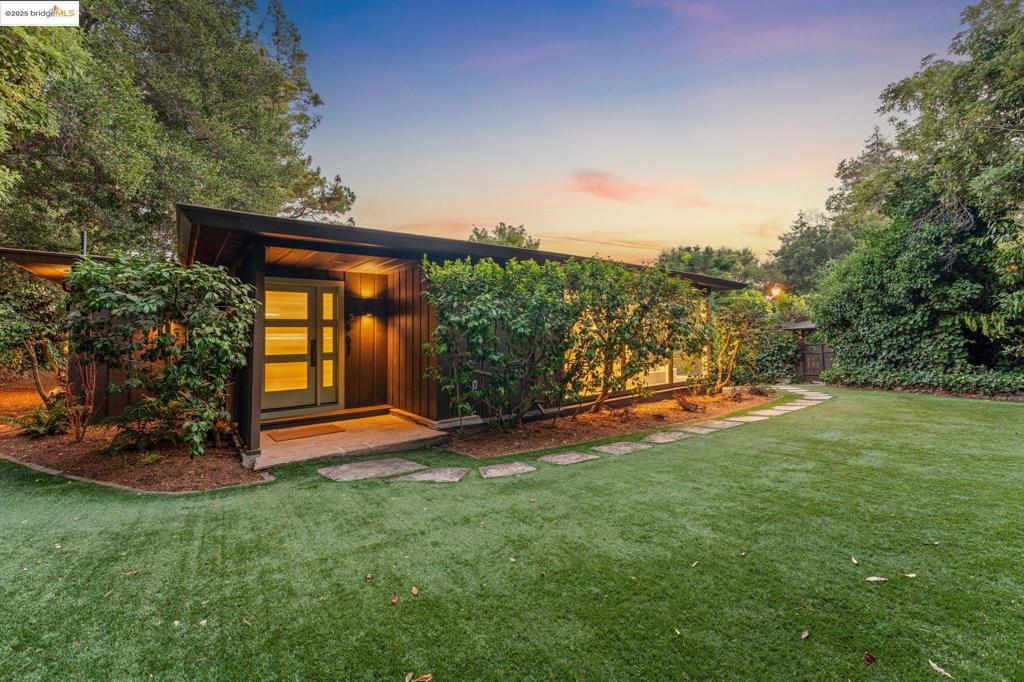 Renovated mid-century home on the Piedmont side of Montclair, this private sanctuary offers expansive, level gardens designed for entertaining, dining under the stars, & play. Some Bay views! Walls of glass frame the lush, private outdoor spaces from the spacious living room and sunken conversation pit, creating a seamless indoor-outdoor flow. Legend has it, this home once hosted President Jimmy Carter and boasted one of the chicest tiki bars around—designed and decorated by the famed owner of Trader Vic’s. Upon entering there is a louvered wall that opens to a large light filled living room & dining area. Redesigned kitchen with new appliances, Oak cabinetry and access to the garden. An additional media room 4BD/3.5BA, includes a luxurious primary suite w/a walk-in closet, deck, freestanding tub, walk-in shower, & dual sinks. Additional Bedroom & Bath located on the main level, while the lower level offers a flexible media room or home office separated by a custom wood shelving system, two additional bedrooms, full bath, laundry, & access to a private patio. Detached two-car garage, additional parking. New roof & two zone AC & Heat. The home’s prime location offers quick access to San Francisco, Montclair Village shops, dining, top rated schools & East Bay Parks.
