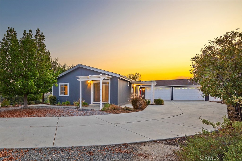 This manufactured home is on a permanent foundation and sits on approximately 3.59 acres, spread across two parcels (APNs 924-110-013 and 924-110-014). Located in Wine Country, the property offers excellent privacy, incredible views, and a peaceful setting that still keeps you close to shopping and freeway access.
A long, tree-lined cement driveway leads to a custom 4-car garage. The home features an open layout with large windows and doors that bring in natural light and showcase the surrounding scenery. French doors and sliding glass doors offer easy access to a large patio, garden area perfect for relaxing or entertaining.
The land is beautifully maintained with plush landscaping, mature trees, and a large storage shed to keep all your tools, garden supplies, or anything else you need to store. Every room in the house has a view, and the elevated position of the home gives it a “top of the world” feel. Come check this one out!