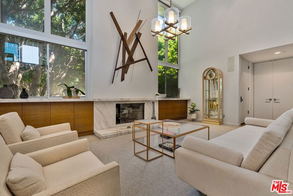 Only 3 blocks from Santa Monica's renowned Montana Avenue, this remodeled penthouse offers 3 bedrooms, 3 baths, a loft office, and a private 500 square foot rooftop deck all designed for elevated coastal living. Framed by lush greenery, the expansive 2-story living and dining areas offer serene privacy through oversized windows, anchored by a custom architect-designed fireplace. The chef's kitchen features poured glass countertops, premium appliances, a breakfast area, and a wine cooler. Two spacious bedroom suites occupy the lower level, each with en-suite baths, while the upper floor boasts a versatile third bedroom/office space, a powder room, and a light-filled loft with a built-in two-person partner's desk. A sprawling, sun-drenched rooftop deck framed by lemon & fig trees, fragrant blooms & herbs and privacy fencing is perfect for entertaining or unwinding with a cocktail under the stars. Bonus features include a private gym (or storage) accessible from the rooftop deck, custom built-ins in the living room and bedroom. Included are two parking spaces and additional storage. Low HOA dues!
