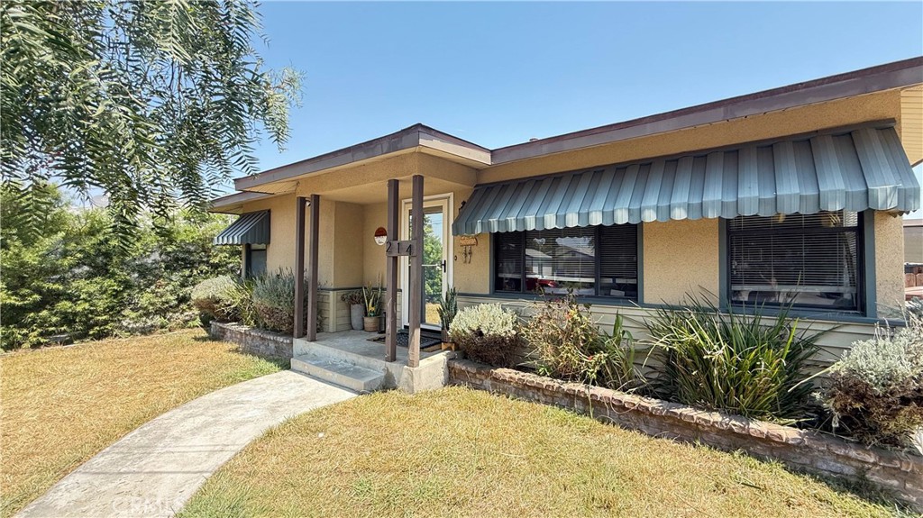 This beautifully updated home enjoys both a large front and backyard. Enter into the spacious living room with views of the front yard. The remodeled kitchen includes shaker cabinets, granite countertops, a range, dishwasher and microwave. The primary bedroom is spacious and has an updated bathroom with travertine shower and sliding glass door to the backyard. There is a convenient inside laundry room. The home features central heat and air, laminate flooring and carpeting. The converted approx. 350 sq. ft. garage is perfect as a bonus room or office. The property is fully fenced with tall redwood fencing and a secondary storage building or workshop. Owners will consider pets, please submit.