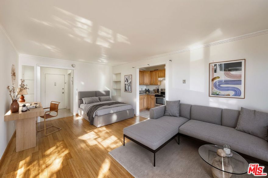 Bask in the rhythm of city life in this sunlit Koreatown studio, where modern style meets the energy of Los Angeles' most dynamic neighborhood. The updated kitchen features sleek granite countertops, rich wood cabinetry, and stainless-steel appliances that make cooking both functional and enjoyable. A cozy dining nook sits nearby, perfect for morning coffee, quiet meals, or entertaining friends. Warm wood flooring enhances the main living area, creating a welcoming and open feel, while the entryway offers plenty of space for shoes, bags, and daily essentials. A spacious closet with mirrored sliding doors provides ample storage and adds depth to the space. The bathroom features a modern vessel sink and thoughtfully designed shelving for extra organization. Step outside to your private balcony overlooking the lively street below, ideal for enjoying fresh air and LA sunshine. One dedicated parking space adds extra convenience. Situated in the heart of Koreatown, you're surrounded by some of the city's best restaurants, nightlife, and entertainment, including The Wiltern and world-famous Korean BBQ with a short distance to Downtown LA and West Hollywood.