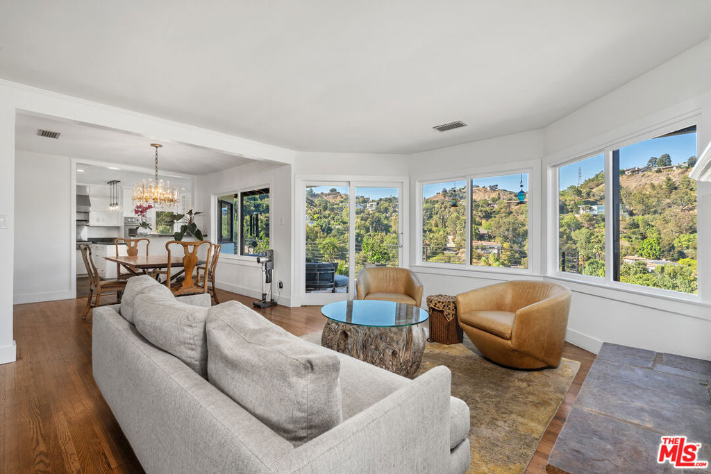 This stunning residence has been transformed through an extensive, chic remodel, offering the perfect blend of sophistication and contemporary style. With an open, light-filled floor plan, it feels like a penthouse suite overlooking the European Riviera. Walls of glass frame sweeping, far-reaching views while filling the interiors with natural light. The dramatic living room flows seamlessly to a large terrace ideal for al-fresco dining and entertaining. A gourmet kitchen, equipped with top-of-the-line built-in appliances, makes every meal an experience.The gorgeous primary suite features a massive walk-in closet and opens directly to lush gardens. Outside, discover a virtual orchard of fruit trees, expansive patios, and serene spaces designed for indoor/outdoor living at its best. Additional highlights include:Hardwood floors throughout, Spacious 2-car attached garage, Exceptional privacy and tranquility on a coveted cul-de-sac One of the finest pied--terres in the Hollywood Hills, this home epitomizes California luxury living.