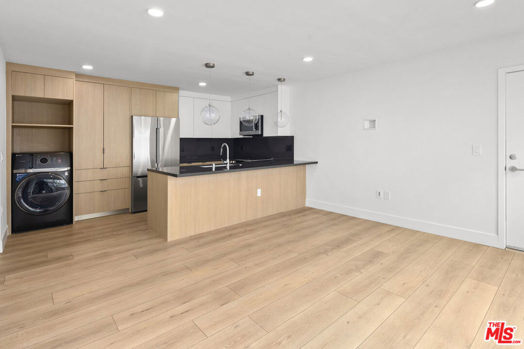 Be the first to live in this just-completed renovation: a brand-new 1-bedroom, 1-bath home in the heart of Santa Monica's coveted Ocean Park neighborhood, just three blocks from the beach and two blocks from Main Street. Inside, a thoughtful remodel combines warm wood tones with sleek finishes for a modern coastal feel. The kitchen is equipped with Bosch stainless steel appliances, PentalQuartz counters, soft-close custom cabinetry, and an eat-in peninsula. Wide-plank floors run throughout the open living area, while oversized windows bring in natural light. The bedroom features tranquil greenery views and a spacious closet with a customizable Elfa system. The bathroom is equally polished, with abundant storage and a clean, modern design. Additional highlights include in-unit laundry, mini-split A/C, and access to an expansive community roof deck with panoramic ocean views - the perfect spot for sunsets. Street parking is available with permit (no assigned parking). Landlord prefers 14 month lease term.