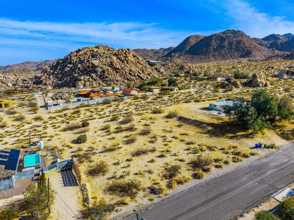 Discover an exceptional vacant lot for sale in the highly desirable Panorama Heights area of Joshua Tree. This flat parcel presents a unique opportunity to build your dream home or a lucrative short-term rental investment, set against a backdrop of stunning views and close proximity to natural attractions. Situated in Panorama Heights, the lot offers an elevated position with breathtaking vistas of the Joshua Tree Valley and direct views of Joshua Tree Park, known for its magnificent natural rock formations. The nearby Kellogg Doolittle house, just a street away, enhances the neighborhood's charm with its impressive mountain and rock views. With the national park boundary just 500 feet from the property line, you'll have easy access to explore the wonders of Joshua Tree National Park. This remarkable property comes with completed plans for a stunning 2,100 sq ft modern ranch house featuring three bedrooms and two bathrooms. The design includes a pool, spa, sunken fire pit, and a spacious outdoor patio with an outdoor kitchen, perfect for embracing the outdoor lifestyle Joshua Tree is famous for. The master suite offers a truly unique experience with a shower that incorporates the area's distinctive rock formations. The plans are ready for submission or can be customized to suit your preferences, allowing you to create a home tailored to your vision. Utility hookups, including water, electricity, septic system, and cable, will be necessary to fully develop the property.
