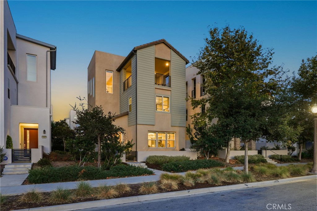 VIEWS, IRVINE SCHOOLS & ADDED PRIVACY BUFFER! This 4-bedroom plus third-floor flex space shows like a model offering unobstructed views of Great Park’s lush greenbelt and Bosque Trail, no front neighbors, and a peaceful buffer of open space in one of Irvine’s most coveted communities. The VIEWS make this home a RARE find! THE MOST DESIRED FLOORPLAN – Enter into a spacious great room-style layout with open living, dining, and kitchen featuring GE Monogram smart appliances and a large walk-in pantry. Step out to a private patio with space to dine, grill, relax, and play complete with a tranquil bubbler that attracts beautiful songbirds.The first floor also hosts a full bedroom and bathroom, perfect for guests or multigenerational living, PLUS direct garage access with an EV charger, floor-to-ceiling built-ins, and overhead storage. Upstairs, the generously sized primary suite captures greenbelt and sunset views, high ceilings, and includes a custom walk-in closet with spa-like bath. Two additional bedrooms with custom closets, a full bath, and a laundry room complete the second level.The third floor offers an oversized flex space with an expansive deck catching panoramic sunset and city-light views, perfect for a home office, gym, playroom, or even a fifth bedroom. Additional upgrades include:
– End-of-cul-de-sac lot with green space between neighbors
– Full Ring alarm system (including cameras) + Nest smart smoke detectors
– Upgraded carpet and padding
– Rolling blinds (3 motorized) + aftermarket sliding screens on all doors. You’ve got to see these views in person! Sunsets, greenery, Bosque Trail from every key living space and a privacy buffer that makes all the difference. Zoned for award-winning Irvine Unified schools with one low HOA and access to premier community amenities.