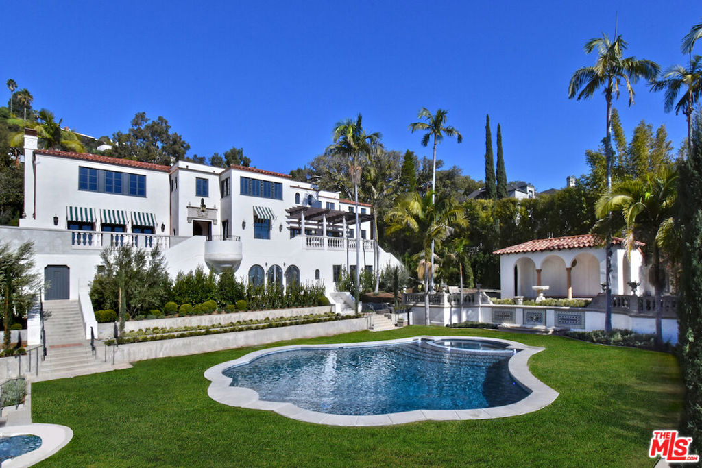 This architecturally stunning 1920s Mediterranean Estate, on a rare 3/4 flat acre parcel with panoramic views from downtown to the ocean, has been meticulously restored and updated under the direction of renowned architect Richard Manion to create the ultimate in dreamy old Hollywood glamour with today's top curated style. Originally built for silent film director/composer Victor Schertzinger on exquisite parklike grounds, this unparalleled offering in prime Los Feliz is south facing and flooded with light. Romantic, beautiful, and private. Commanding views of downtown greet you at the original front door and entry with imported custom Portuguese tile wainscot and antique Dalle de Bourgogne limestone flooring. A grand living room with custom plaster ceiling has seven pairs of doors leading to inviting patios and viewing decks. An original Batchelder tiled wood-burning fireplace. The formal dining room boasts original stenciled wood-beamed ceiling, a 1920s Italian Neoclassical carved giltwood and iron 18 light chandelier, and dramatic views of downtown and the hills beyond. Christopher Peacock designed kitchen with white oak cabinetry, proprietary nickel hardware, custom pewter hood, and an integrated butcher block. 60" Bluestar platinum series ten burner range, Subzero refrigerators, refrigerator/freezer drawers, under-counter beverage refrigerator, and ice maker. The butler pantry has a custom marble sink, drying board, and nickel wire mesh cabinet fronts. Accordion windows provide easy pass-through of food for outdoor dining on the oversized patio. The kitchen also opens to a family room and informal dining room, creating a comfortable, stylish space for family and guests to hang out. The upstairs contains the primary suite which offers breathtaking views of the city, gas fireplace with limestone hearth and window benches with drawers. The primary bathroom has Thermasol steam shower, heated book-matched Carrera floors & wainscotting. There are three additional bedroom suites and a sizeable laundry room with 2 sets of side-by-side washers and dryers, built-in ironing center and custom cabinetry and linen storage. The third floor lower level opens to an entertainers' lounge with access to the backyard, a large gym with full bathroom, a screening room or recording studio, and a guest quarters/office suite with private entrance and access from Richland Ave. and a full separate kitchen featuring Bosch dishwasher, cooktop, pull out hood, refrigerator/freezer, bathroom and laundry hookup. Hotel style grounds include lush landscaping designed by Hoffman & Ospina Landscape Architects, 4 working bronze and Malibu tile fountains, 3 of them original to the property and painstakingly restored, and a dramatic lyre-shaped pool rebuilt to its original beauty but with added spa and water feature. There are also two detached guest cottages both with views, bathrooms, and heat and air, and a pool pavilion with outdoor shower. Other features include: New roof with original 100-year-old tile saved and replaced. New electrical 600 amp service. 6 HVAC systems trenched to the rear of the yard. New custom wood windows with integrated pull-down screens. Crestron Home automation System. Copper gutters. Plaster walls throughout. Custom, concealed, in-wall speakers. Designated area for 3-floor elevator. City views from all major rooms and bedrooms.
