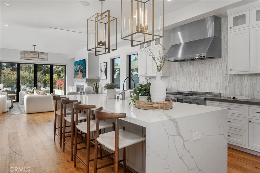 Experience elevated coastal living in this newly built modern farmhouse, ideally situated less than one mile from Pacific Coast Highway in the heart of Huntington Beach. Designed to capture the essence of refined seaside living, this residence combines timeless craftsmanship with contemporary elegance just moments from Main Street’s acclaimed dining, boutique shopping, and vibrant entertainment as well as walking distance to the beautiful outdoor shopping venue, Pacific City.

The inviting 800 sq.ft. front patio sets a distinguished first impression, offering an idyllic setting for open-air gatherings with a built-in fire pit, barbecue, artificial turf, and thoughtfully illuminated landscaping. Inside, expansive bi-fold doors open to create a seamless indoor-outdoor flow, uniting sophisticated design with relaxed coastal ambiance.

At the heart of the home, the chef’s kitchen features stunning white quartz countertops, a marble backsplash, a walk-in pantry, and a grand center island. Professional-grade appliances include a six-burner double oven range, complemented by Restoration Hardware lighting and custom cabinetry that exude luxury and functionality.

Distinctive touches throughout the home include an 80-bottle glass wine room, a versatile den with a Murphy bed, and multiple en-suite bedrooms that provide comfort and privacy for family and guests. The primary suite is a true retreat, offering a private fireplace and a spa-inspired bath designed for indulgence and tranquility.

The third-floor bonus room enhances the home’s entertainment appeal with a wet bar and private terrace showcasing sweeping views—an ideal vantage point for sunsets and summer fireworks.

With five full bathrooms and exquisite finishes throughout, this residence embodies the pinnacle of modern coastal sophistication, delivering an unparalleled Huntington Beach lifestyle just steps from the ocean.