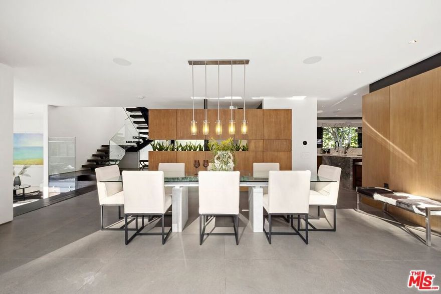 Set on a 16,270 sq ft upslope lot, this renovated two-story, four-bedroom home sits about a mile from Sunset Boulevard on a quiet Bel Air cul-de-sac.  More than 190 feet of street frontage, two driveways,  a 2-car garage, and plenty of off-street parking as well.  The existing home is approximately 3,550 sq ft, with the potential to expand to around 5,500 sq ft or more depending on configuration.Inside, the home was recently renovated in a warm, modern style with new aluminum windows and doors, bringing in natural light and hillside views from nearly every room. Perimeter hedging provides privacy throughout. The living room has floor-to-ceiling glass, 10+ foot ceilings, and a limestone floor and an Italian marble fireplace.The first floor features an entertainer's kitchen with walnut cabinetry, Brazilian quartzite counters, a 12-foot island, and appliances from Thermador, Miele, and Gaggenau, including gas, electric, and teppanyaki cooking modules. A family room with built-in audio, a 5-foot gas fireplace, and a 16-foot pocketing glass door opens to the backyard. The dining room seats 12 comfortably and includes walnut wall panels, a 155-bottle wine display, and another full-length pocket door to the outside.Upstairs, all bedrooms have hardwood floors and modern walnut doors. The main suite includes two walk-in closets, a built-in Bose system, and a large bath with a soaking tub, dual showers, and mountain views. Three additional bedrooms are spacious and bright; one is en-suite. A fourth bedroom with wood-clad walls also works well as an office or gym.The backyard offers over 2,000 sq ft of flat space with room for an infinity pool, plus more than 3,000 sq ft of additional flat side and front yard. Plans for expansion are available. The home also includes upgraded plumbing, electrical, heated floors, and full app-controlled systems throughout.