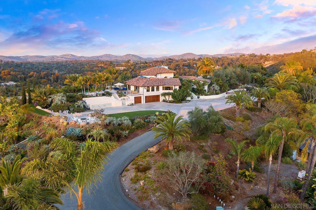 Elegantly situated on 5.61 hilltop private, peaceful acres sits this one-of-a-kind Santa Barbara style custom Spanish Adobe with stunning panoramic views to the ocean, hills, valley and covenant. Located in the West side Covenant, tucked behind a gated, long winding driveway this 5196 sq. ft. charming Weir Brothers estate home is surrounded by lush, mature botanic gardens where microclimates abound to accommodate citrus groves, food forests, kitchen gardens and colorful flower beds. Bespoke walking trails naturally surround the estate allowing one to enjoy the outdoors on one’s own land and connect with nature. A circular courtyard entry wraps around and welcomes you into the warmth of softly arched doorways and windows, dramatic vaulted ceilings with reclaimed wooden beams and walls of windows and doors providing endless views. An abundance of natural light streaming in throughout the day allows you to enjoy the rich Southern California indoor-outdoor lifestyle. Enjoy ocean view sunsets and dine alfresco from the spacious domed ceiling gourmet kitchen and dining room that opens to a sprawling wraparound deck overlooking the private pool with spa, pool bath with sauna, pizza oven and fire pit. With three private ensuite bedrooms downstairs and a panoramic view Master ensuite Bedroom upstairs this flowing open floor plan lends to privacy and serenity. Elegantly situated on 5.61 hilltop private, peaceful acres sits this one-of-a-kind Santa Barbara style custom Spanish Adobe with stunning panoramic views to the ocean, hills, valley and covenant. Located in the West side Covenant, tucked behind a gated, long winding driveway this 5196 sq. ft. charming Weir Brothers estate home is surrounded by lush, mature botanic gardens where microclimates abound to accommodate citrus groves, food forests, kitchen gardens and colorful flower beds. Bespoke walking trails naturally surround the estate allowing one to enjoy the outdoors on one’s own land and connect with nature. A circular courtyard entry wraps around and welcomes you into the warmth of softly arched doorways and windows, dramatic vaulted ceilings with reclaimed wooden beams and walls of windows and doors providing endless views. An abundance of natural light streaming in throughout the day allows you to enjoy the rich southern California indoor-outdoor lifestyle. Enjoy ocean view sunsets and dine alfresco from the spacious domed ceiling gourmet kitchen and dining room that opens to a sprawling wraparound deck overlooking the private pool with spa, pool bath with sauna, pizza oven and fire pit. With three private ensuite bedrooms downstairs and a panoramic view Master ensuite bedroom upstairs this flowing open floorplan lends to privacy and serenity. Endless possibilities abound for future development on this rare ocean view hilltop estate. Build an ADU guest house, tennis court, over-sized garage for the car enthusiast or vanity vineyard on the undeveloped flat all useable west facing parcel with panoramic ocean views! Living off the Grid could be real with the high-tech safety systems that have been installed throughout the property ie., A state of the art Fire Safety and Extinguishment System, a Well with a 15,000-gallon storage tank and 3 reserve tanks enabling you to use both city water and well water, a whole house Solar System, Security System and Wellspring Desalination system. Enjoy the convenience of a short walk across the private cul-de-sac to the San Elijo Lagoon Trails and Upper and Lower San Dieguito parks for a quick hike or family picnic as well as easy access to the RSF Golf Course, Village and Roger Rowe School. Architectural Style: Monterey/Hacienda/Adobe View: Monterey/Hacienda/Adobe Equipment: Pool/Spa/Equipment, Washer Sewer: Sewer Connected Topography: GSL