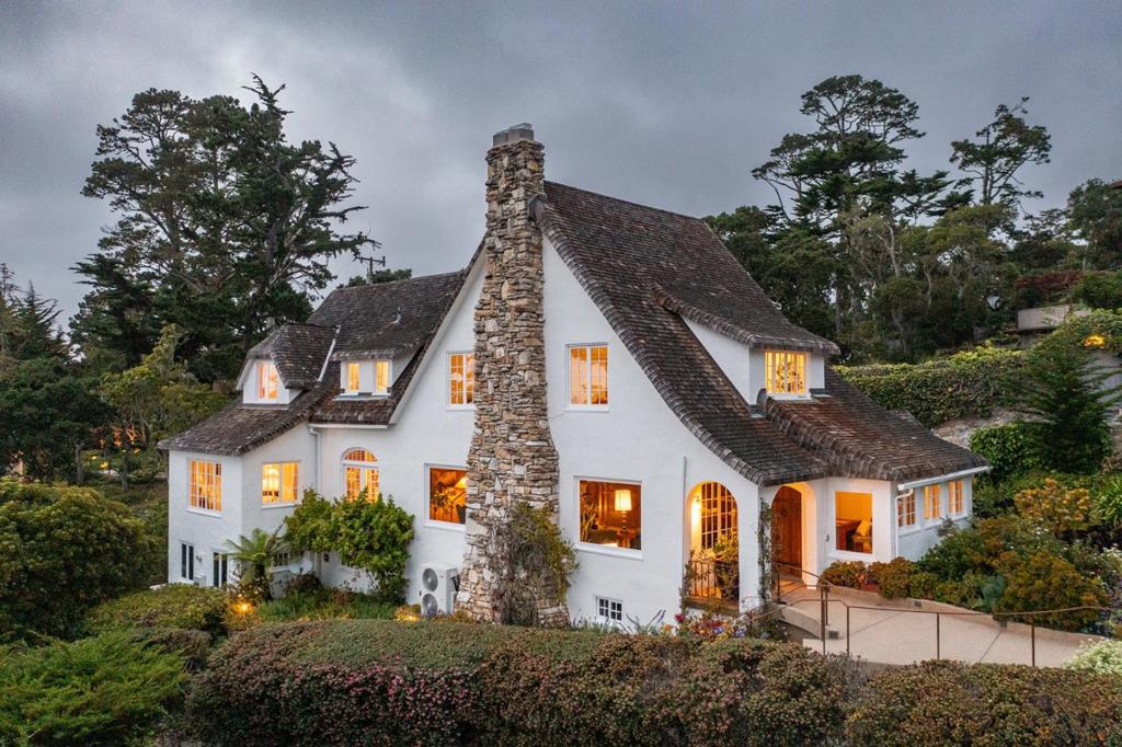 Offered for the first time in decades, this 1925 Tudor Revival gem is a once-in-a-generation opportunity to own a piece of Carmel Highlands history. Designed and built by M.J. Murphy this architectural treasure stands as one of the most authentic and enduring examples of his work. Set on a private knoll above Tickle Pink Inn, surrounded by English-style gardens the residence features hallmark Tudor details inlcuding pitched gables, hand-hewn beams, 2 masonry wood-burning fireplaces and custom retored casement windows true to a 1920's design. With four bedrooms, all with ensuite bathrooms, rich wood-clad walls, most windows facing the Pacific Ocean and multiple french-doors that open to the private, protected courtyard in the back of the home this home offers both emotional resonance and architectural distinction. This home also boasts an elevator, generator and full, mostly finished basement space with an office and workroom. While historically significant, it is not under formal preservation, allowing for flexibility and thoughtful updates. Located just 10 minutes from Carmel-by-the-Sea, this legacy home offers peaceful seclusion and coastal elegance.