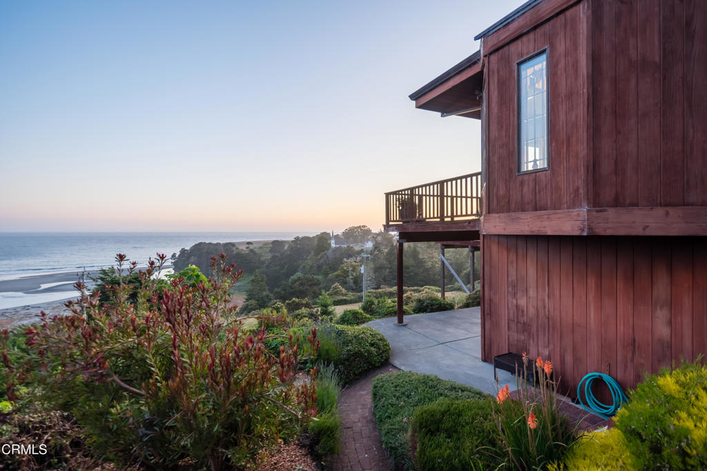 Set atop a grand vista point, with a stunning panoramic view of Big River Beach, Mendocino Bay, and the historic landmark village of Mendocino, this Greene and Greene-inspired Arts and Crafts style home, has long been regarded as the Crown Jewel of Mendocino. Built from sturdy old-growth redwood indigenous to the region, this home has been lovingly maintained and improved upon by its current long-time residents of 25 years. Offering a rare blend of tranquility and modern convenience, the property is but a moment's drive, bike ride, or stroll to local beaches, kayaking, hiking trails, dining, grocery, boutiques, and art galleries. Wrap-around windows and expansive, multi-level decks run the western expanse of the house, opening onto a breathtaking 180-degree view shed. Mornings here are ideal for sunrises and birdwatching. One can watch the ever-changing marine layer and weather systems arrive on the horizon. Evenings offer a kaleidoscope of scenes: sunsets over the ocean, star gazing from the hot tub and decks, moonlight glittering off the nearby waves. The main entry to this home gives way to the ocean view kitchen, dining, and living areas, bathed in warm natural light and is accented with high ceilings, rich old growth beams, and art nouveau inspired figurehead corbels. The kitchen has a Viking range, electric oven, cherry cabinetry with matching cherry panel refrigerator, granite countertops, dining bar, and a wood-burning fireplace with an artisan copper surround. The dining area flows to the north of the kitchen, the skylit living room to the east, where there is an additional wood-burning stove. Adjacent is a sunny office with views of the garden and front entry. To the south of the living area is a wide hallway with a pantry and half-bath, which leads to the Primary Bedroom with ocean views, a walk-in closet, and deck access. The ensuite bathroom has a large skylight, a free-standing soaking tub, two vanities with sinks, a large shower, and a separate WC with low toilet and bidet. Downstairs leads to a two-car garage and laundry room. The downstairs living suite has separate sliding glass door entries, a full bath, ample closet space, two ocean view bedrooms, and its own patio. It has been pre-plumbed and wired for the installation of an en-suite kitchenette, making this space a flexible option for family, guests or long-term renters to reside in. Included in the sale is a backup generator (essential during North Coast winters) and hot tub.