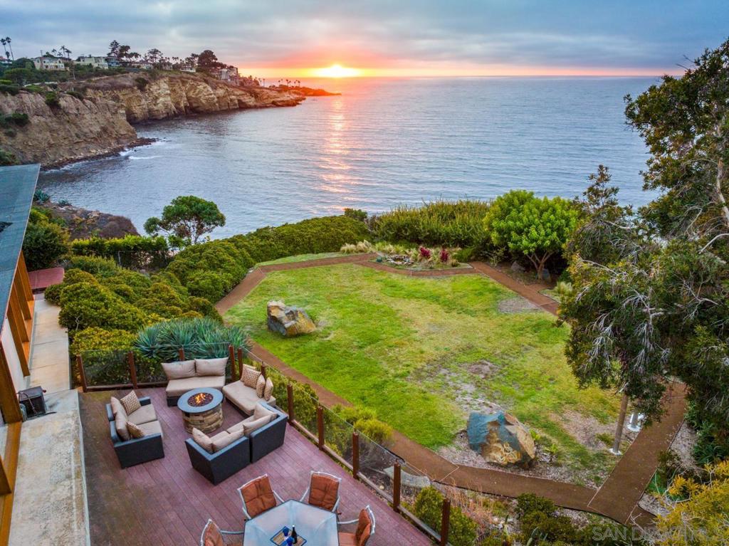 Unparalleled ocean views abound at this truly spectacular Oceanfront residence. Perfectly sited on approximately 0.91 Acres above the Blue Pacific, with views from the La Jolla Cove to the Cliffs of Blacks Beach. Expansive level yard and lush tropical foliage invite you to enjoy the outdoor coastal lifestyle. Single-level Wood and Glass home blends seamlessly into the vista. Floor to ceiling walls of glass capture the amazing views. Curvilinear kitchen island is the focal point of the open floorplan, with the spacious kitchen facing the living and dining rooms, all highlighted by soaring ceilings, glass walls and natural design features. A once in a lifetime Trophy Property. Incredible privacy abounds, starting with the long driveway, set off the street leading to a parking pad and garage that can accommodate 10+ cars. Wooden gate with artistic water feature leads you to the flower filled entry courtyard, and massive front door, that creates a statement upon entry to your "hidden home". Reported to be the largest Oceanfront property, for a detached home, between Marine Street and Scripps Pier. This is a 'hidden home' on an amazing lot, with pathways and trails to explore the nature that surrounds you. In addition to the three bedrooms, there are two additional rooms, used currently as a den/guestroom and the other as an office looking out towards the courtyard. A subterranean room, currently used for book storage would make a wonderful wine cellar. Fully fenced for your dog. Solar panels are owned. Unique features for fabulous entertaining include ample parking for 10+ cars and/or catering services. Very rare to find, large, level lawn and garden on the Oceanfront with views in every direction, plus wrap around decks and patios with seating options for groups and private moments to soak in the views. Secluded spa with views is yet another space for meditation and relaxation at this amazing property. You will never want to leave home. Seller has received Residential Building Records from the County Tax Assessor that says the year built was 1958, it was extensively remodeled in 2002. And to quote the notes on that document... "Magnificent unimpeded ocean and shoreline panoramic views, nearly 180 degrees" Even the city officials are impressed! And you will be as well!