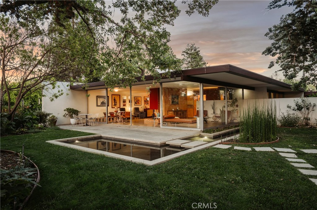 The McSorley House, 1959. Richard Neutra, FAIA. A rare and remarkably intact midcentury modern retreat. This elegant 3-bedroom, 2-bath home sits at the center of a gated, private half-acre lot on a quiet cul-de-sac, surrounded by nature and thoughtfully preserved. Floor-to-ceiling windows and sliding glass doors in the living room and primary suite create seamless indoor-outdoor flow. Birch wood and terrazzo floors run throughout, adding warmth and texture. A wood-burning fireplace anchors the family room, while a large driveway leads to the covered carport. The tranquil reflective pool—drawn from Neutra’s original plans—enhance the serene setting. The spacious pool, added by the McSorley family, completes this iconic architectural escape. A truly special home that embodies the quiet beauty of classic California modernism.